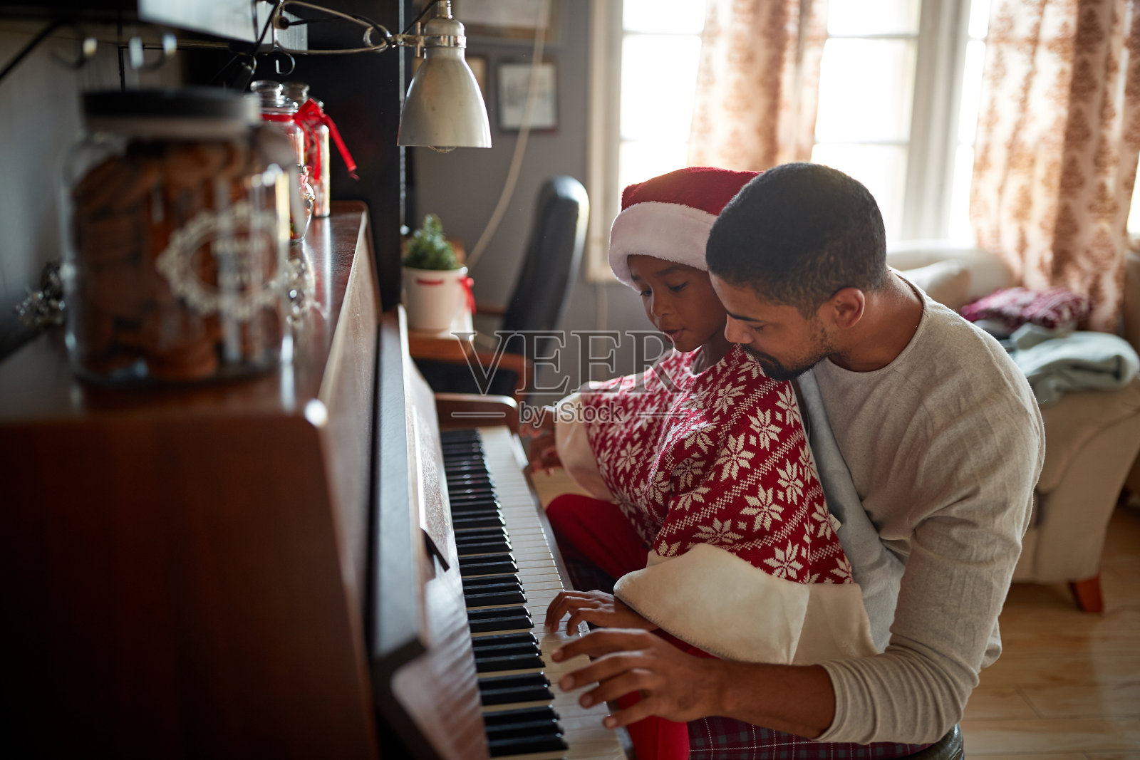 圣诞新年亲子派对：父亲和孩子弹钢琴照片摄影图片