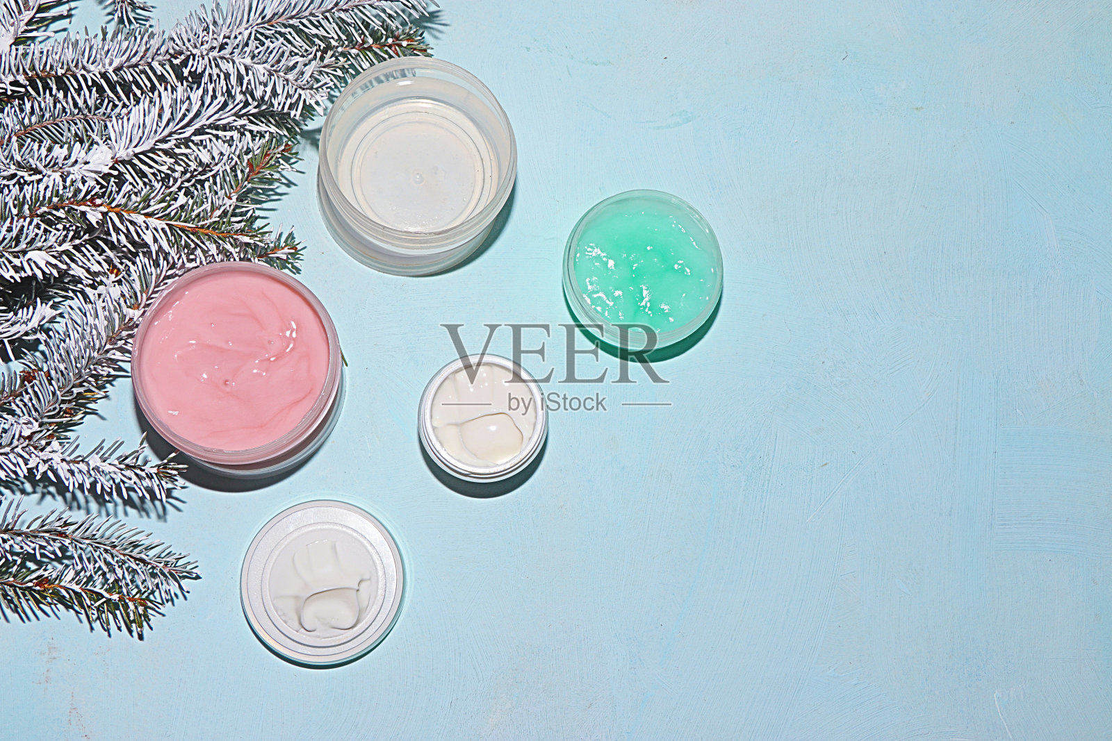 水疗沙龙，销售，一套霜的冬季皮肤护理的背景上的杉木树枝。购物的概念照片摄影图片