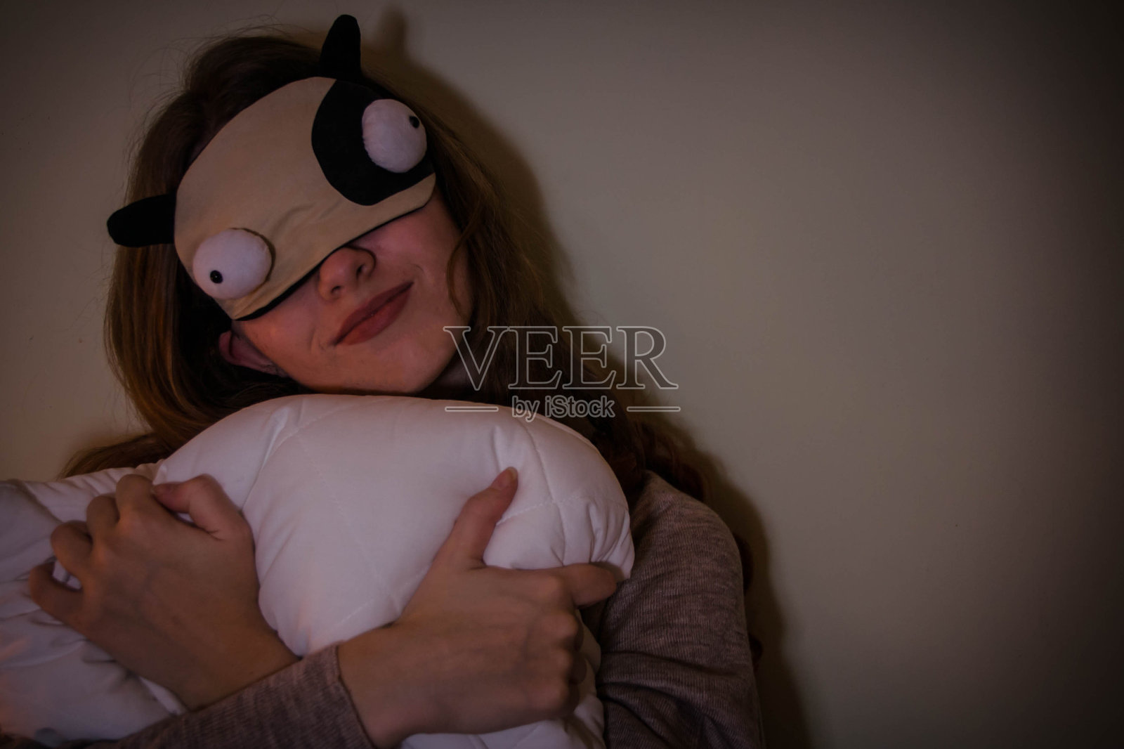 戴着面具睡觉的女孩，还有个枕头参加睡衣派对照片摄影图片