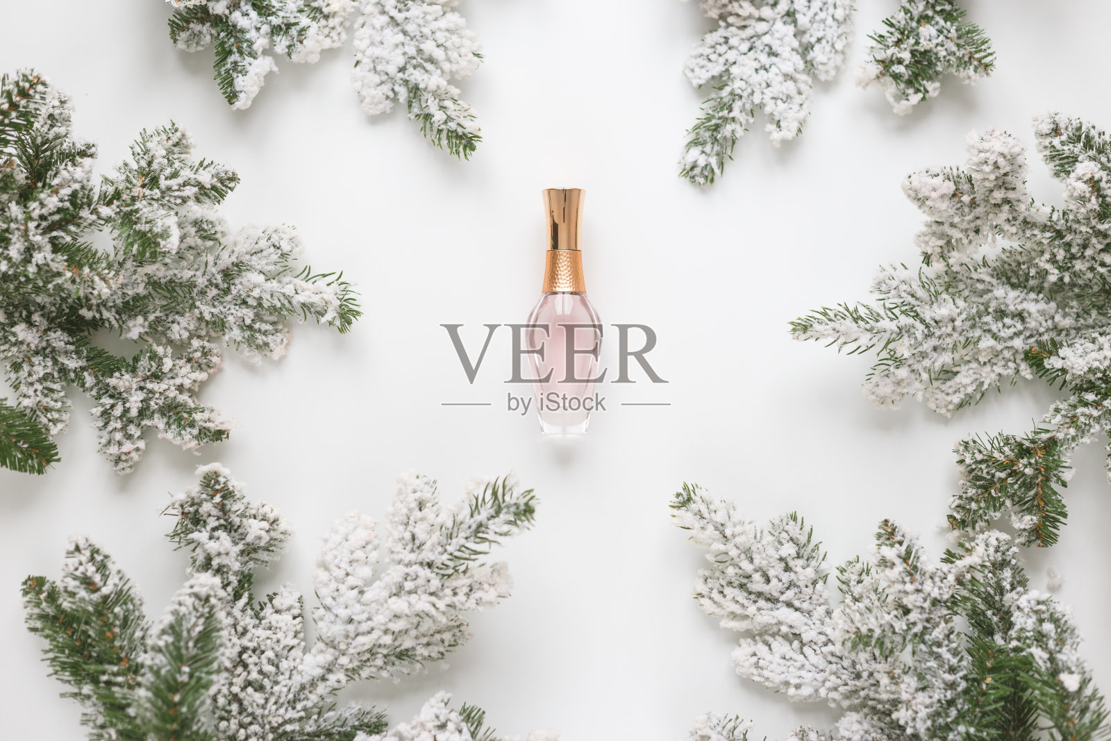 圣诞节的静物画。云杉树枝形成一个框架，中间是香水瓶照片摄影图片