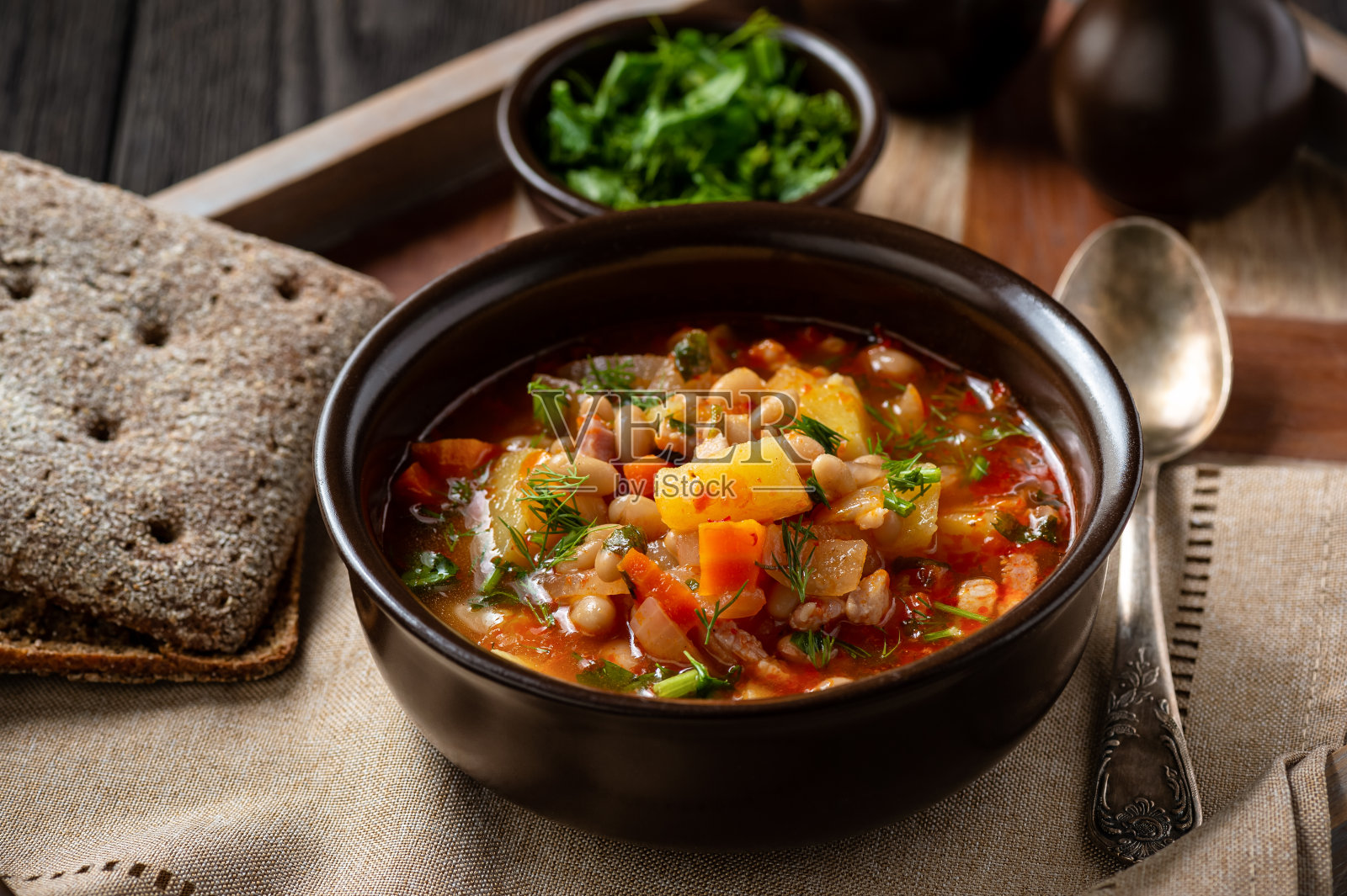 白豆肉汤，放在木托盘上。照片摄影图片