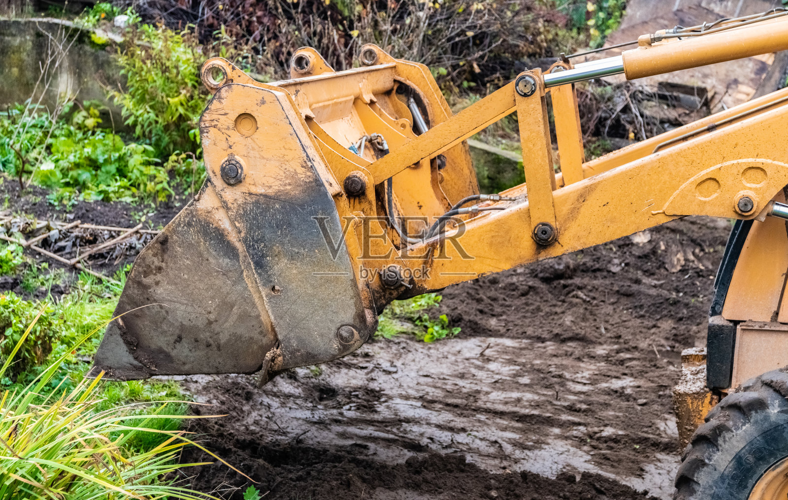 挖掘机的碎片。在住宅区的街道上进行的维修工作。照片摄影图片