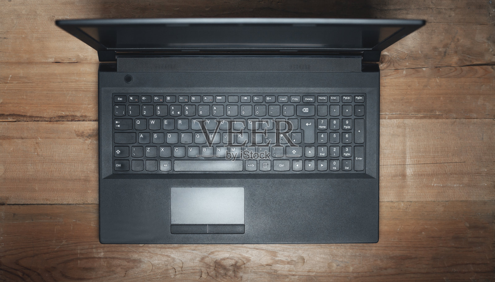 黑色笔记本电脑放在木桌上。照片摄影图片