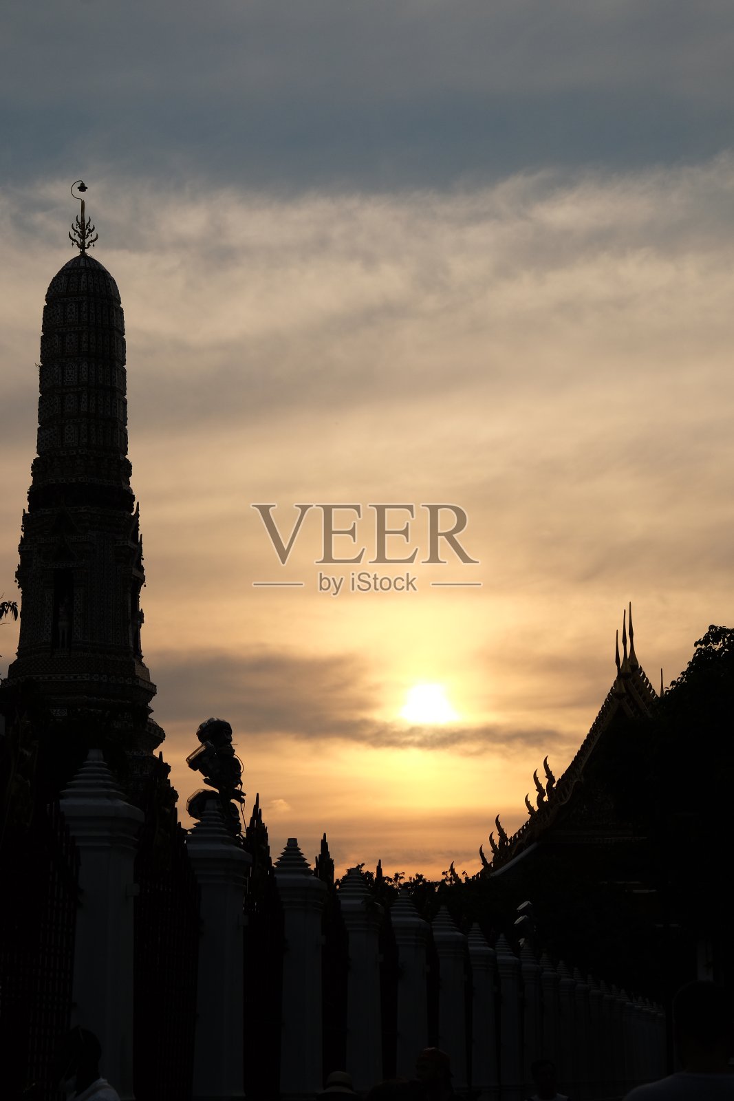 在日落天空的背景下，Wat Arun temple的塔的剪影。照片摄影图片