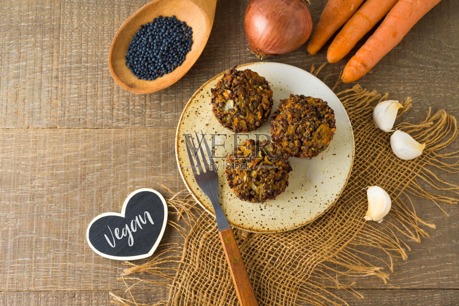 食物与健康饮食观念。小扁豆，胡萝卜和洋葱放在木板上，放在木桌上。照片摄影图片