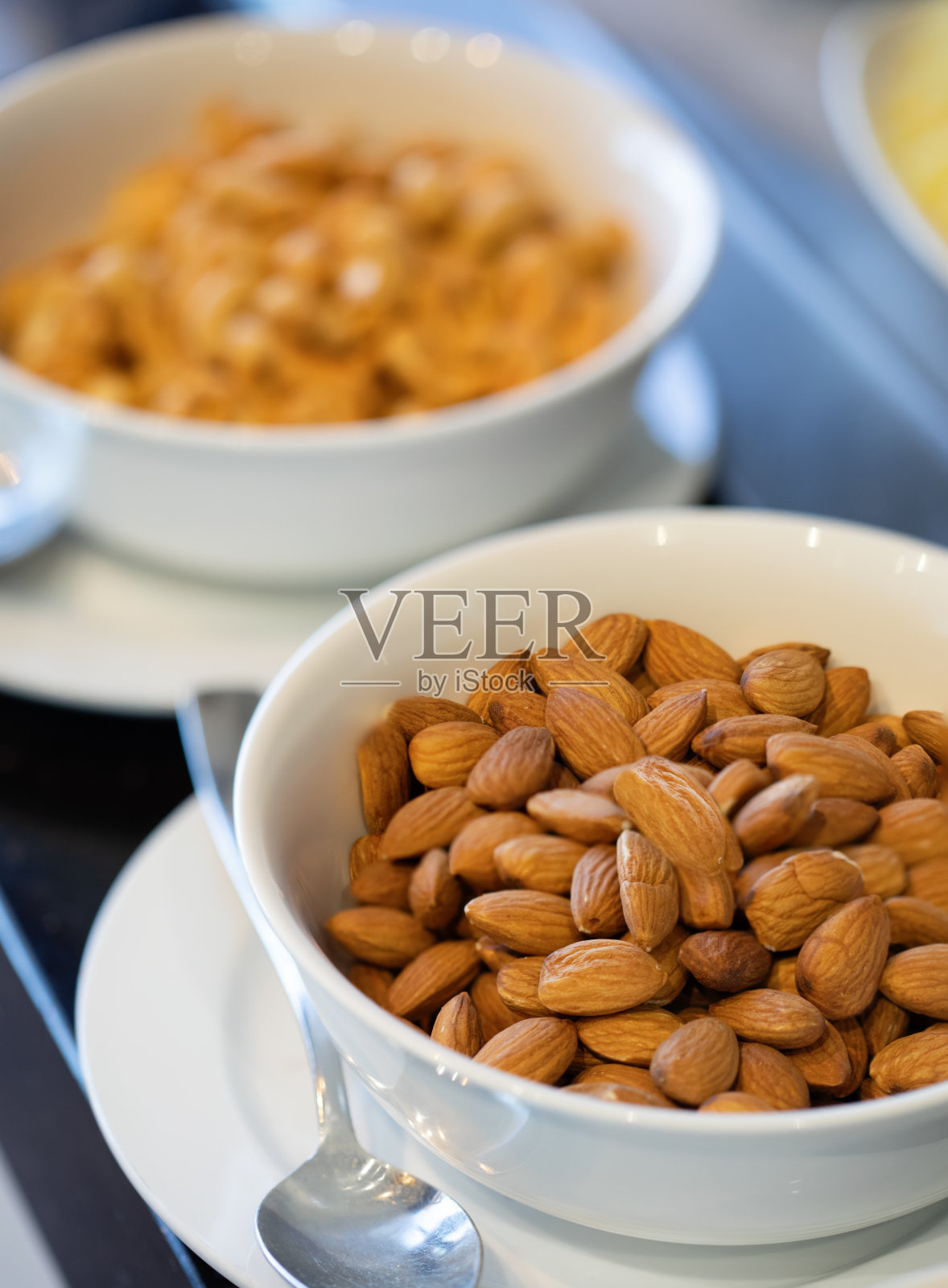 两个装满杏仁和腰果的白碗照片摄影图片