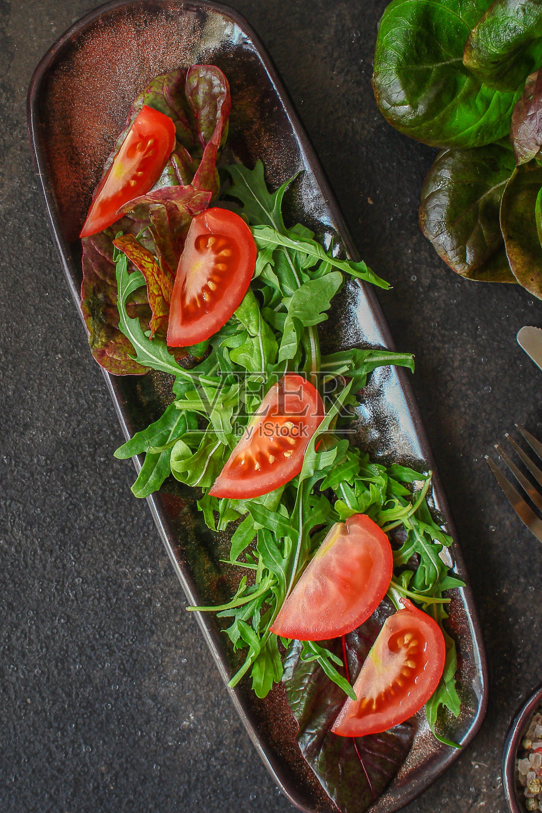 健康沙拉，绿叶沙拉(混合绿色蔬菜，番茄，洋葱，其他配料)。食品的背景。本空间照片摄影图片