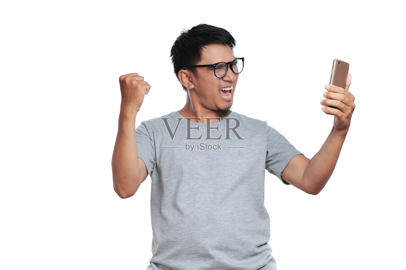 智能手机前的兴奋表情。肖像快乐的亚洲人非常兴奋时，在网上商店得到最好的价格照片摄影图片