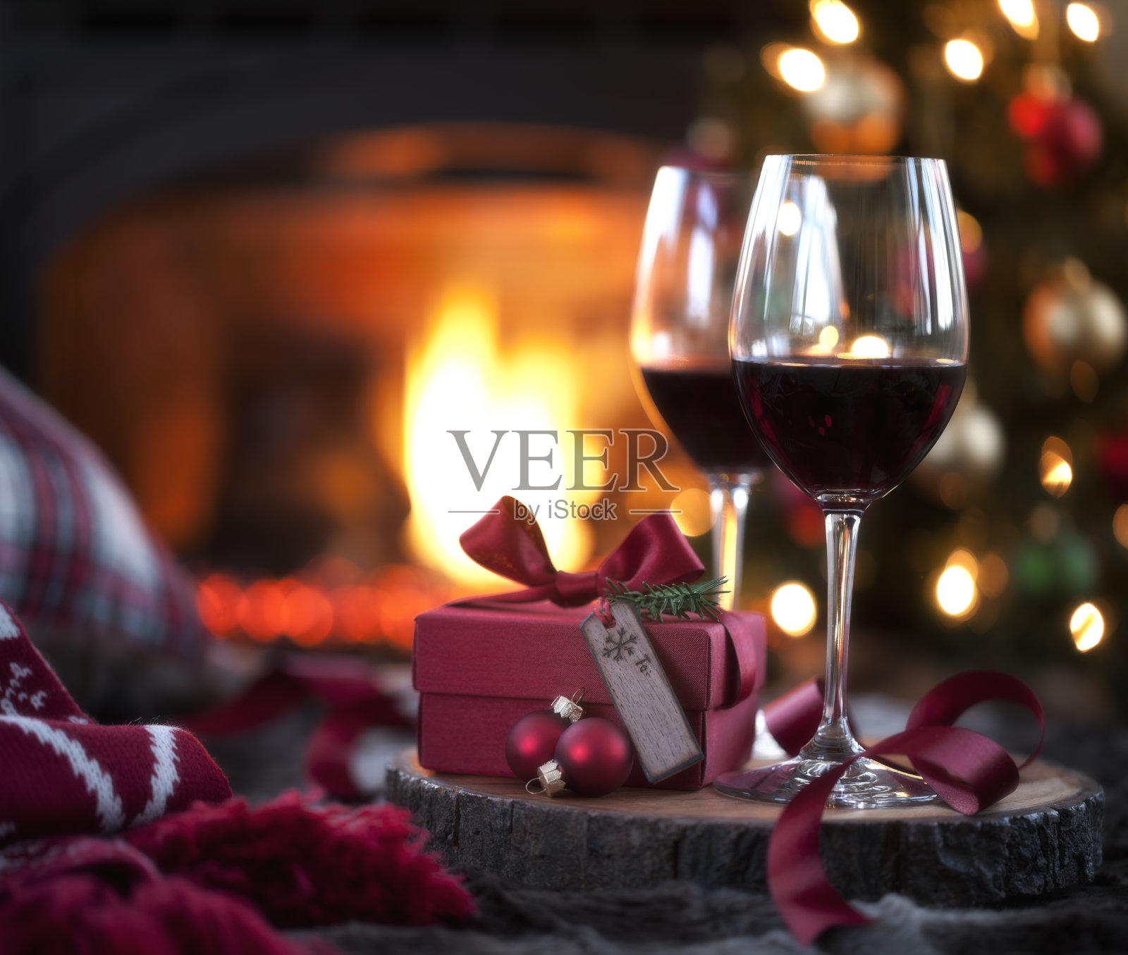 圣诞红酒和礼物在壁炉和圣诞树前照片摄影图片