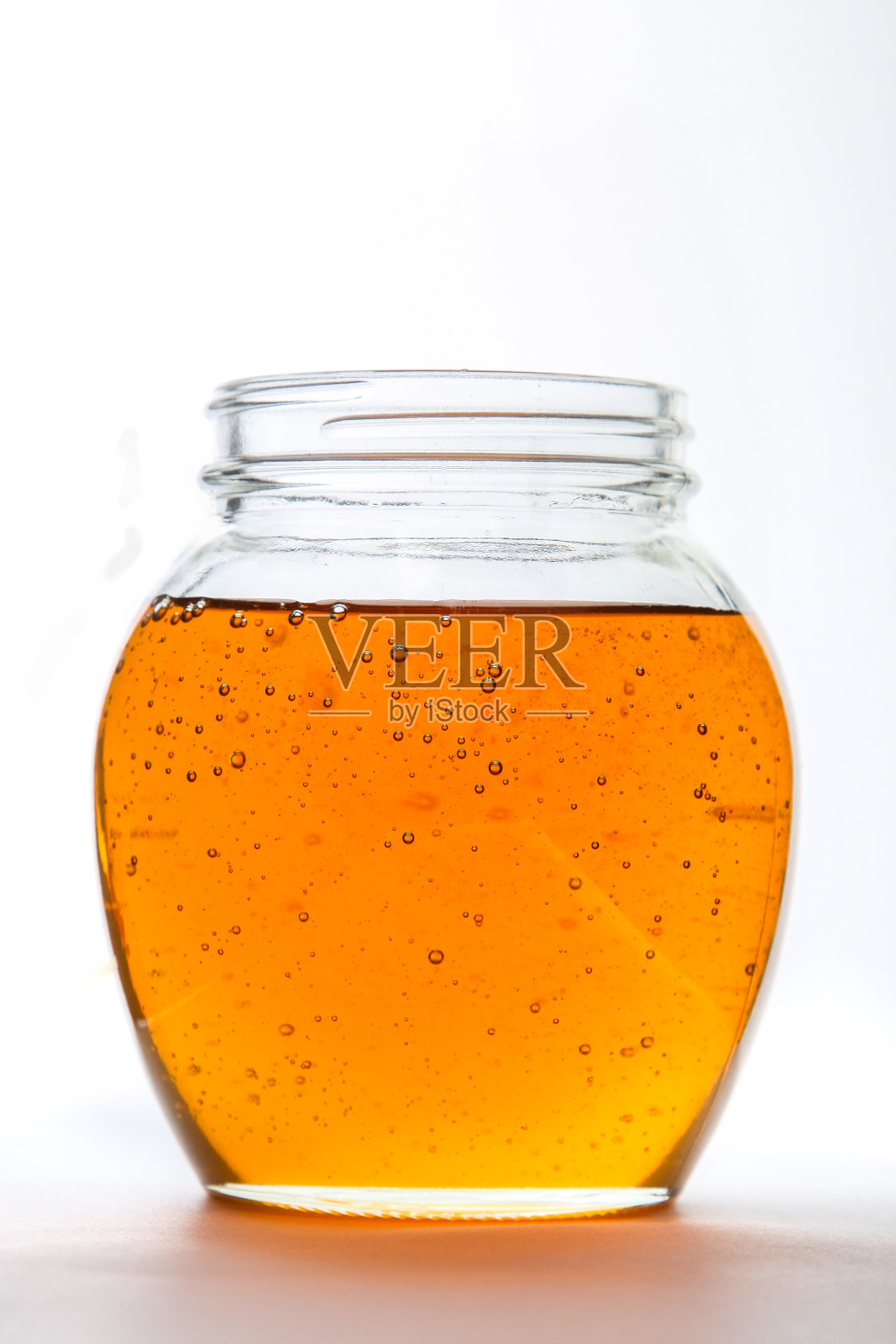 白色背景玻璃罐内放蜂蜜照片摄影图片