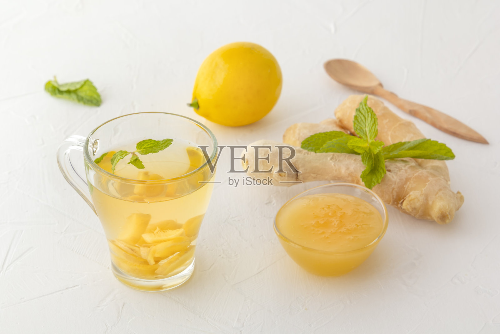 白色木桌上放着姜茶、柠檬、蜂蜜和薄荷照片摄影图片