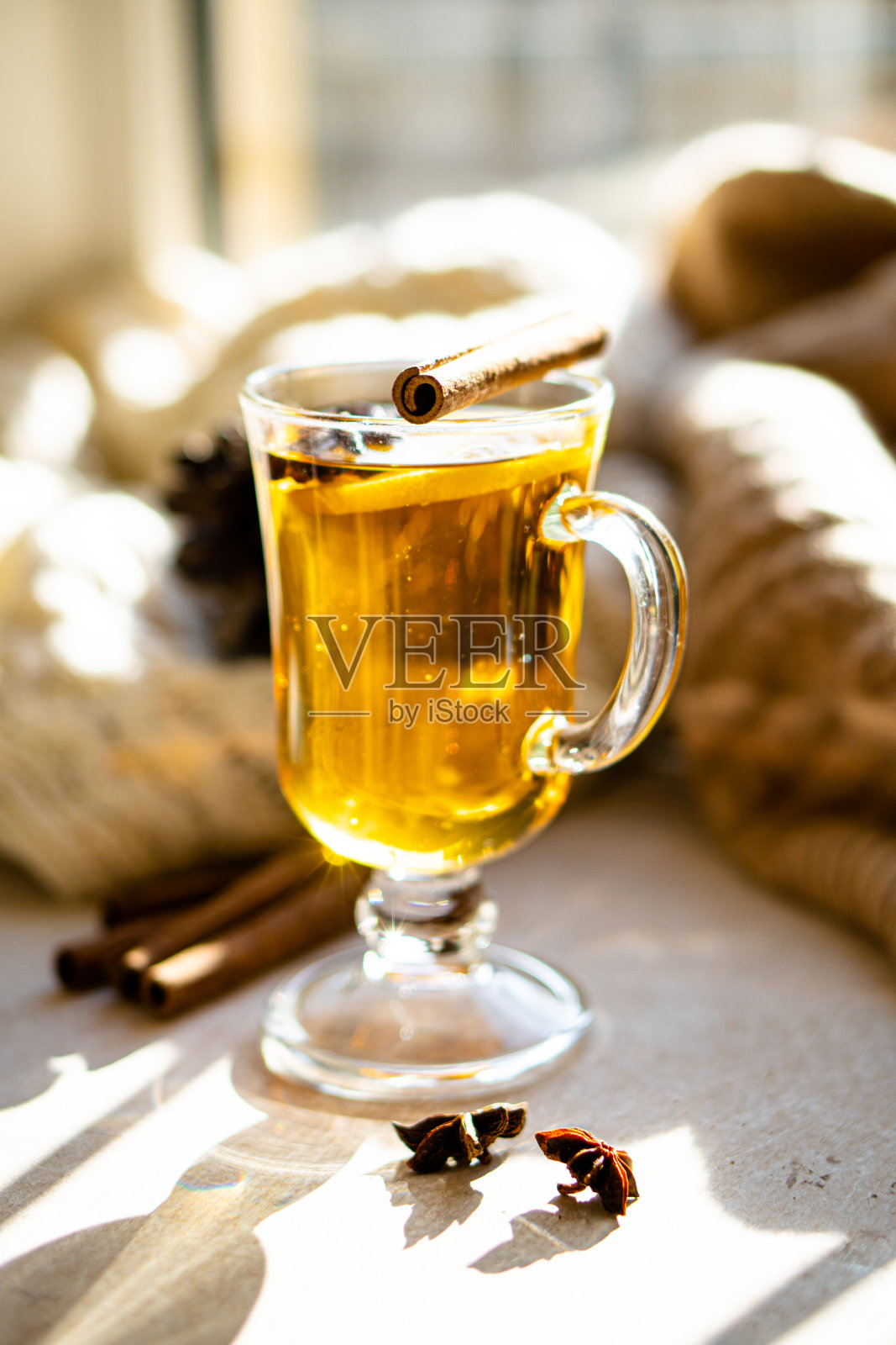 在阳光明媚的日子里，用肉桂和柠檬调制的冬日热饮照片摄影图片