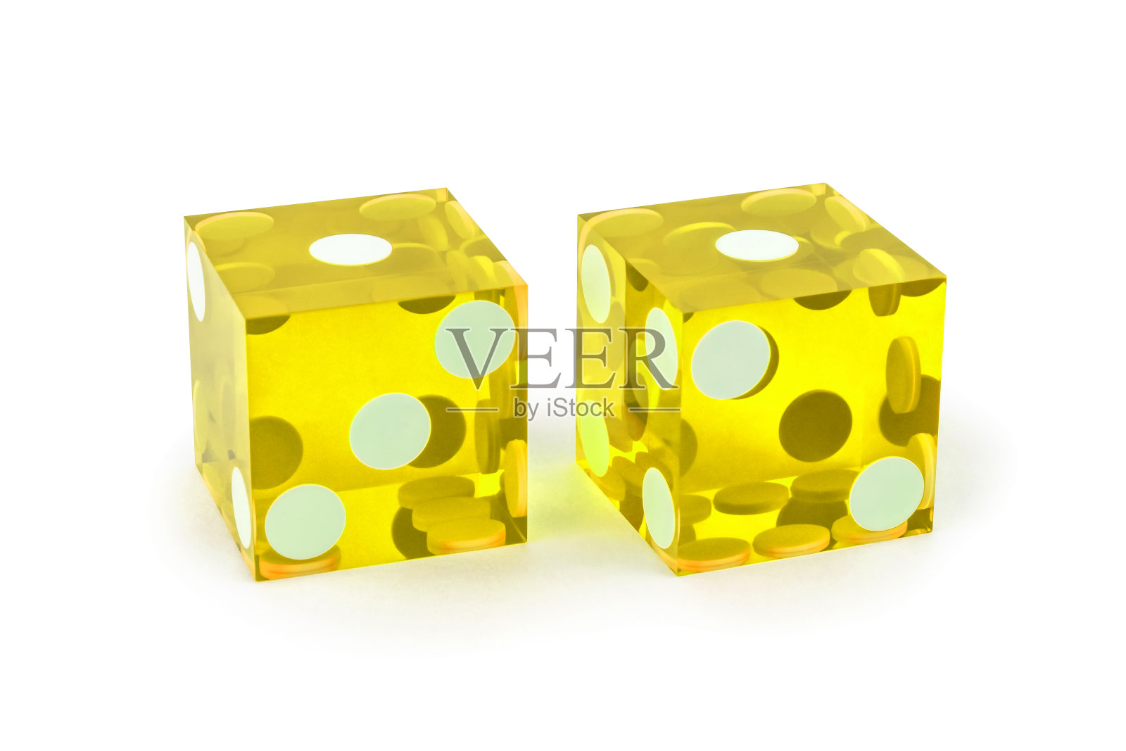 特写的两个专业黄色玻璃骰子。一个又一个，有轻微的阴影，完整的剪裁。微距拍摄，选择性对焦。照片摄影图片