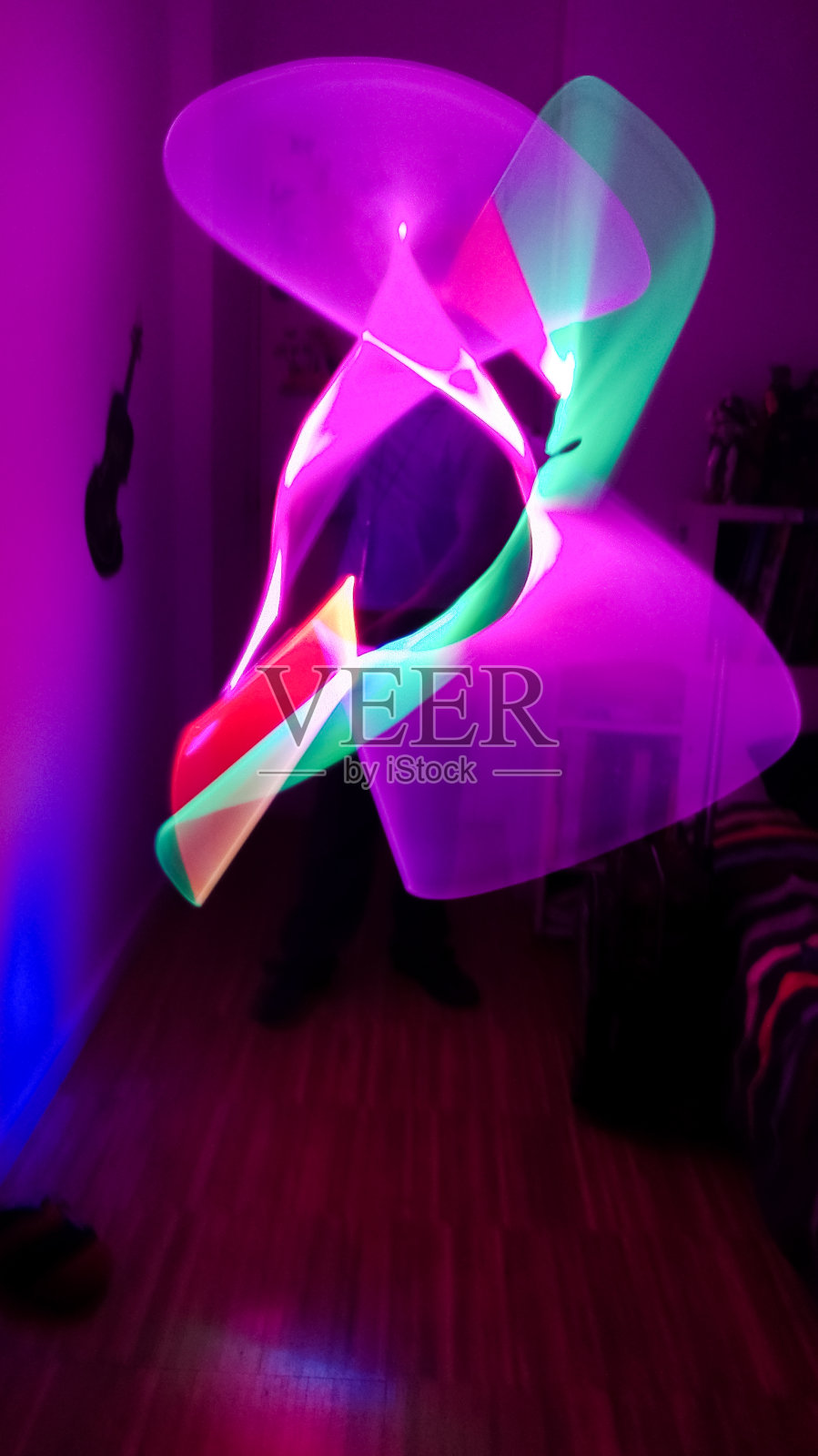 男孩在他的房间里玩着各种颜色的光剑照片摄影图片