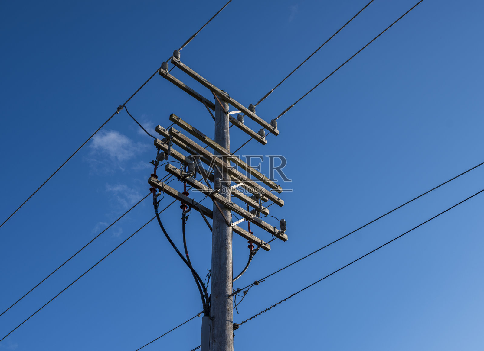 蓝天下的电线杆和输电电缆照片摄影图片