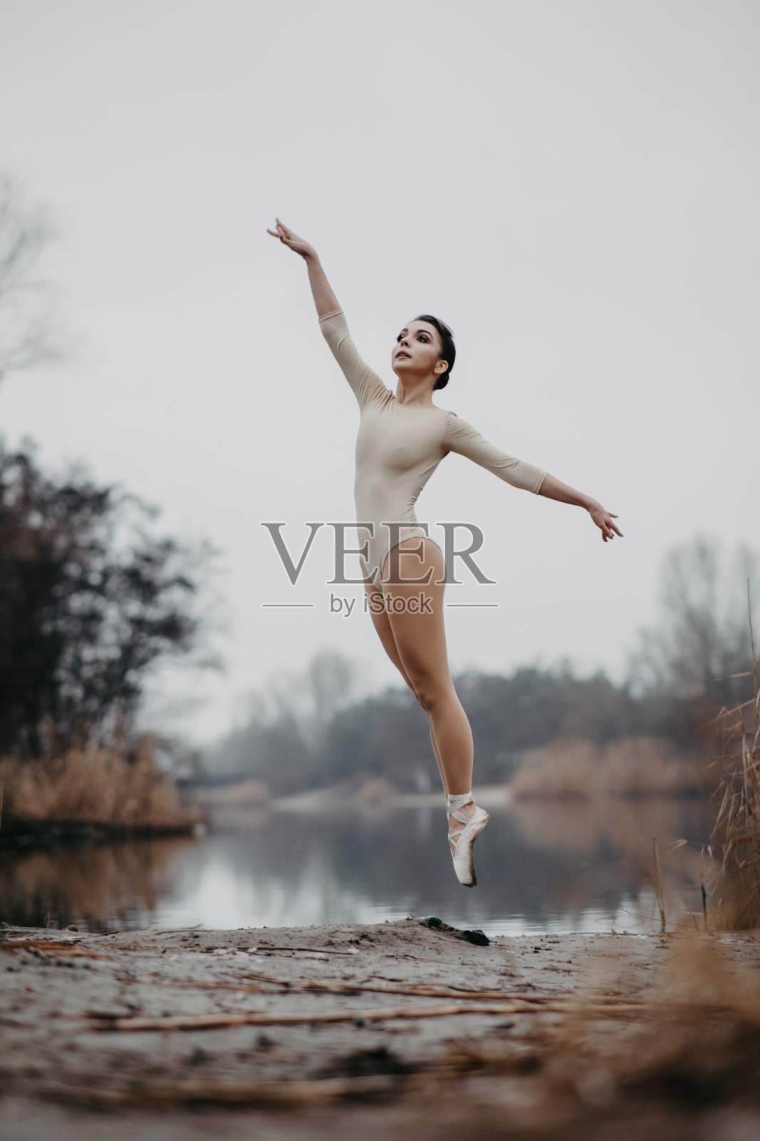 芭蕾舞演员在湖岸跳舞跳跃。照片摄影图片
