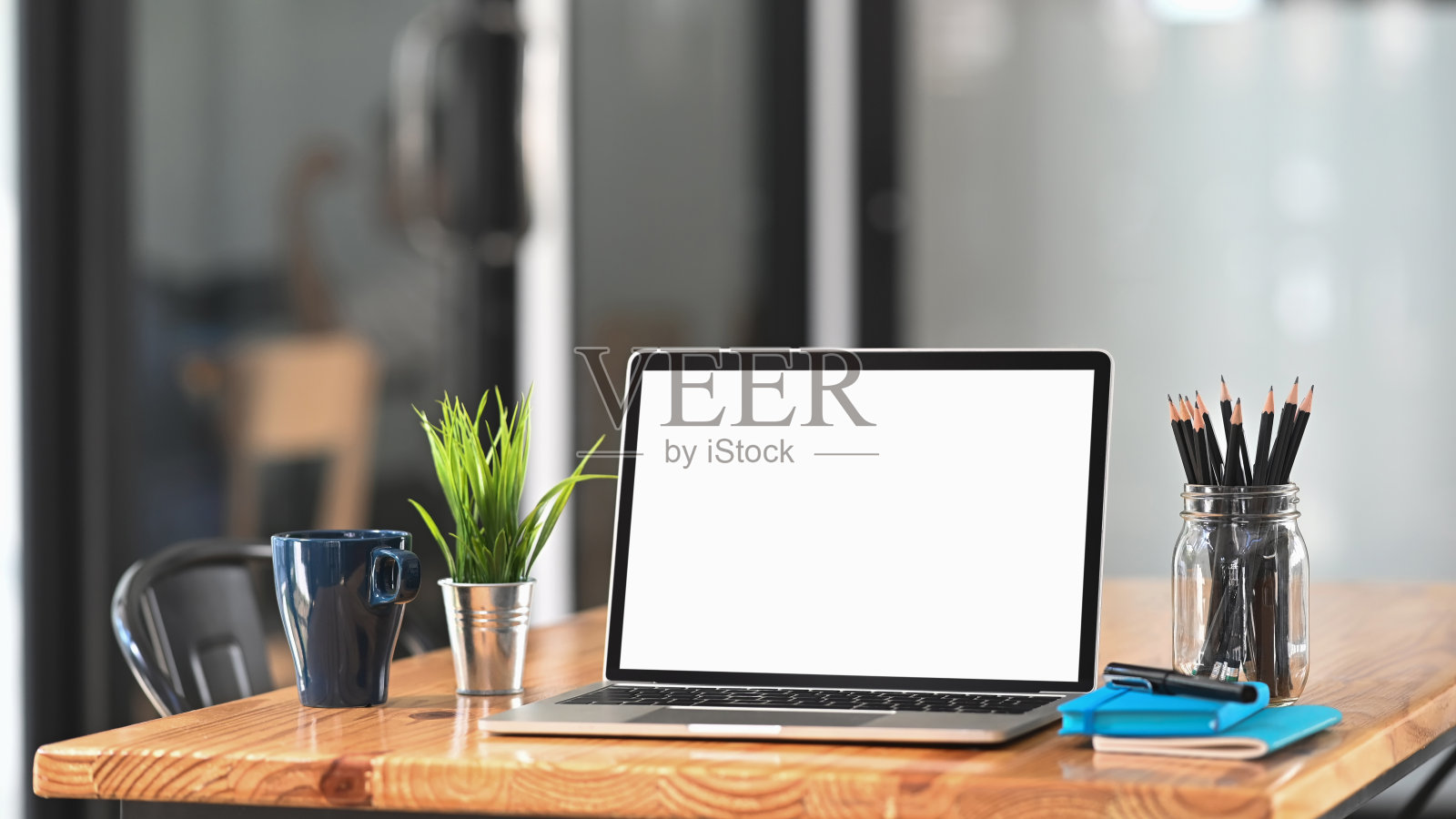 在办公室的工作桌上放笔记本电脑。照片摄影图片