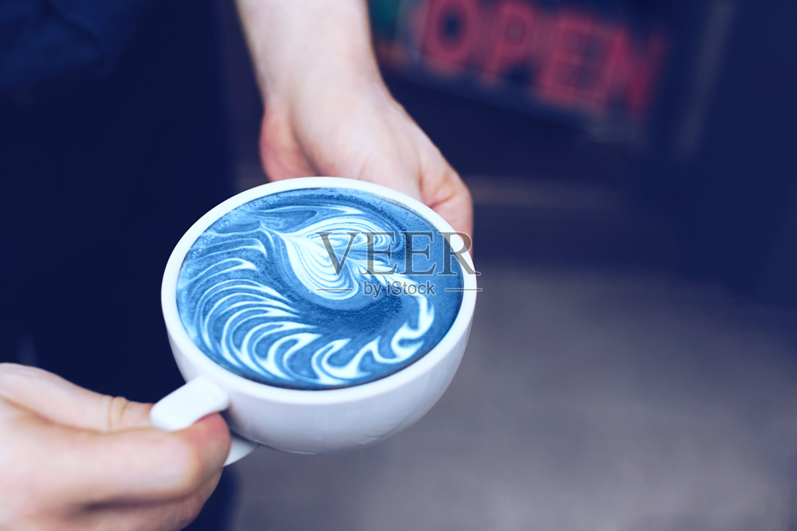 一杯咖啡在男人的手里。照片摄影图片