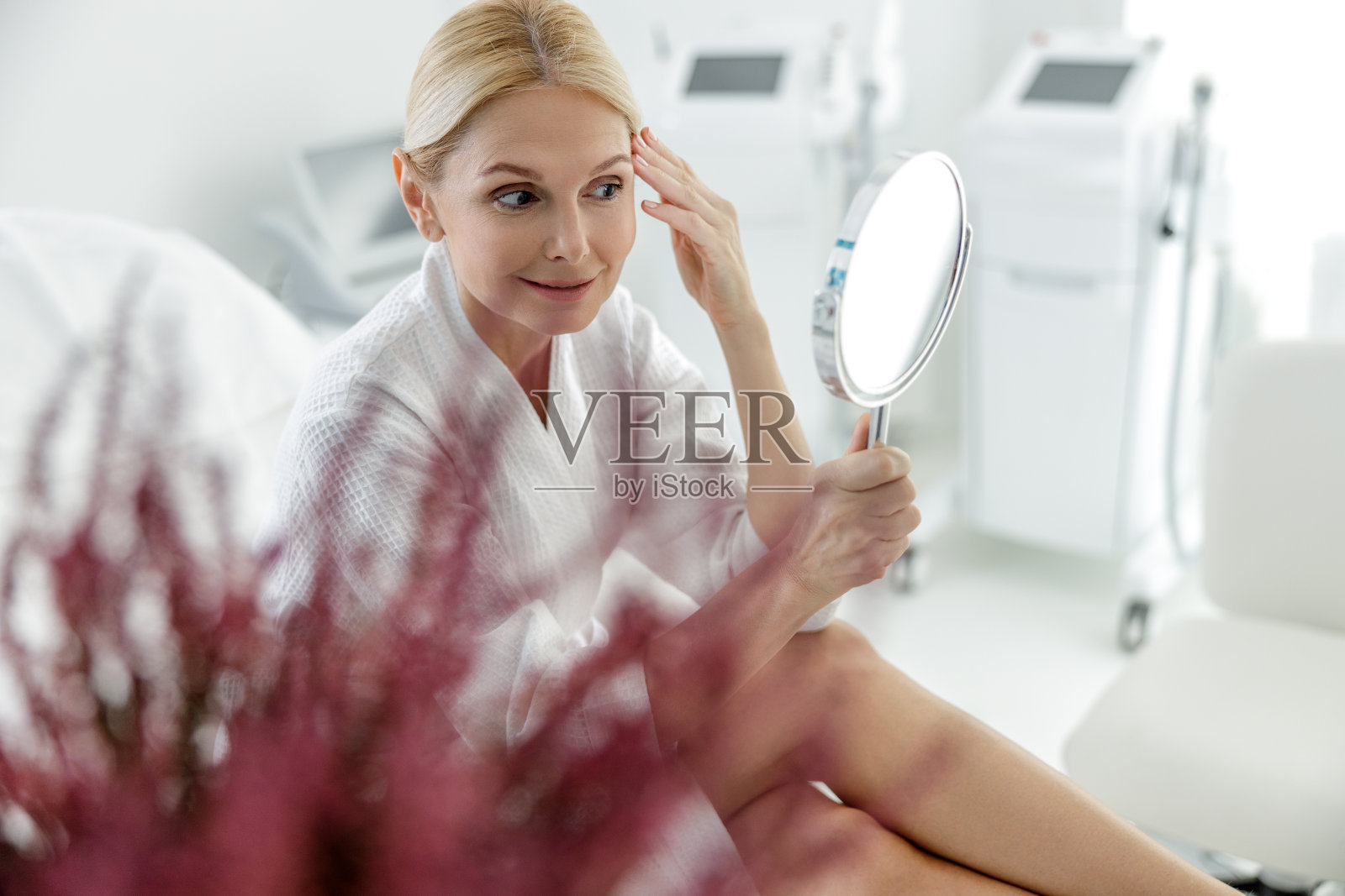 微笑的女人看着脸上的皮肤状况照片摄影图片