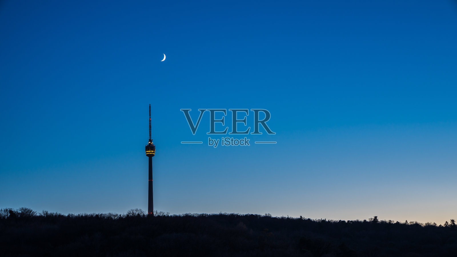 德国斯图加特城市天际线地标电视塔大楼与月亮和蓝色星空在冬天的夜晚被森林包围照片摄影图片