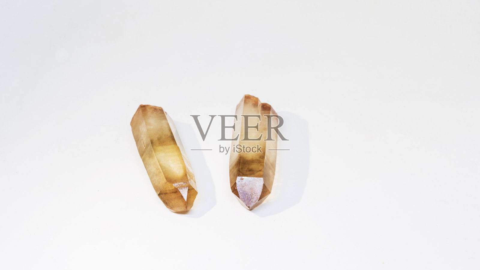 一对烟熏石英抛光水晶点躺在白色的背景。孤立的概念。照片摄影图片