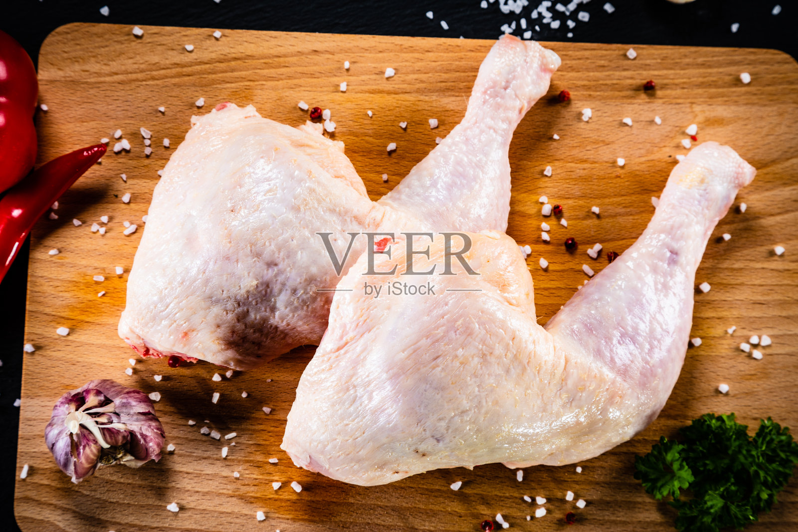 生鸡腿放在砧板上照片摄影图片