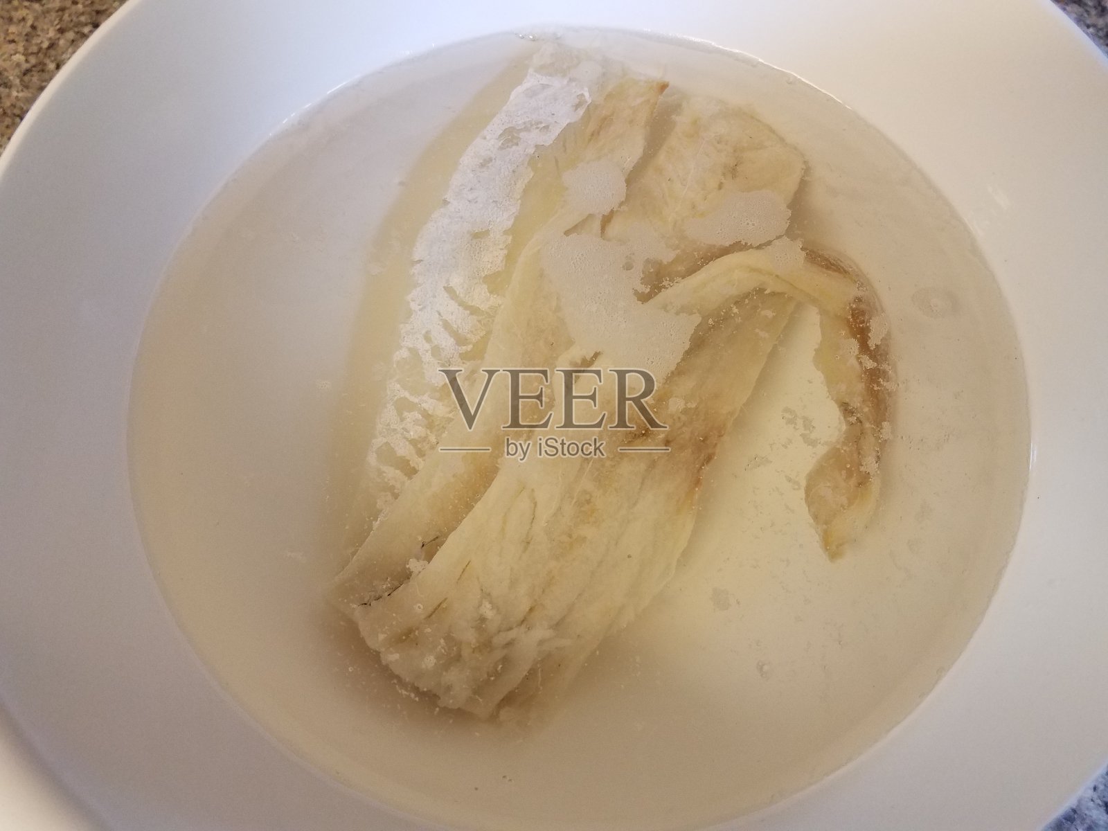 用清水腌鳕鱼放在白碗里照片摄影图片
