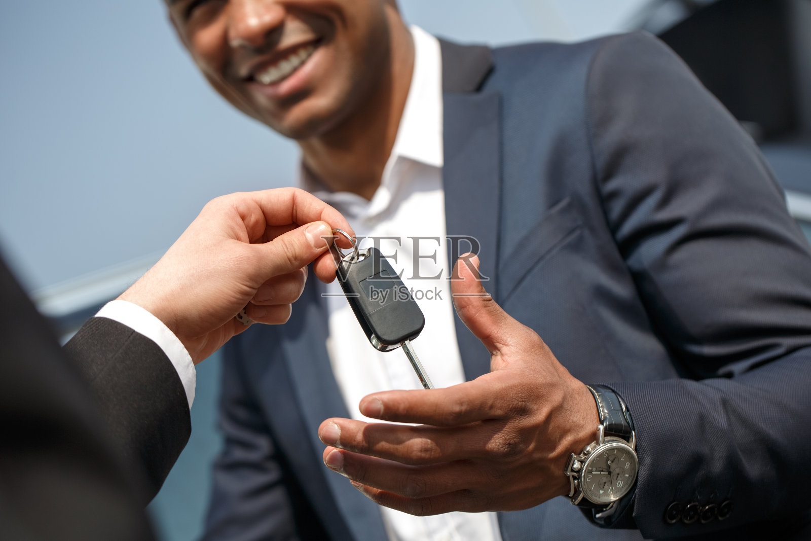 探员把钥匙交给了站在车旁的年轻人，他高兴地看了近景照片摄影图片