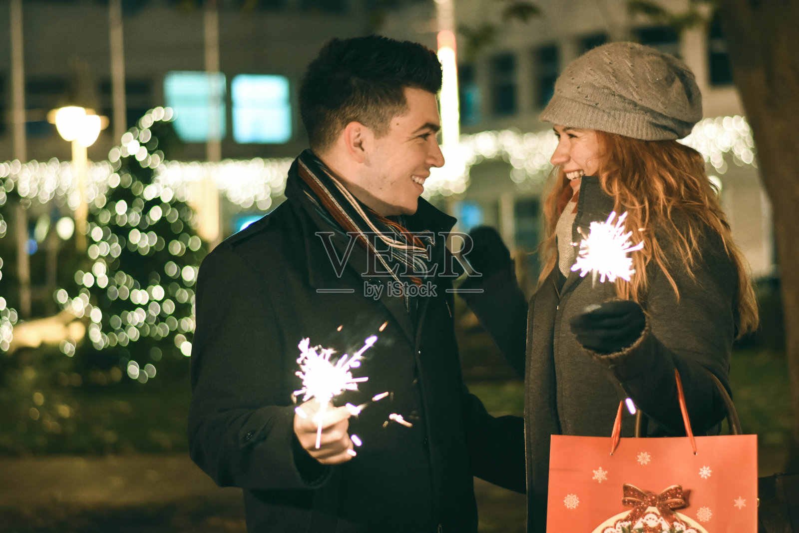 一对年轻幸福的夫妇在洒水器旁等待新年的到来照片摄影图片