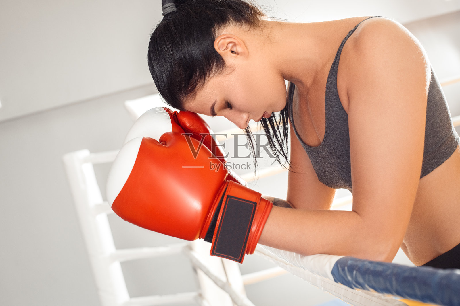 拳击。女人在手套拳击手靠在绳子上环下来疲惫的特写镜头照片摄影图片