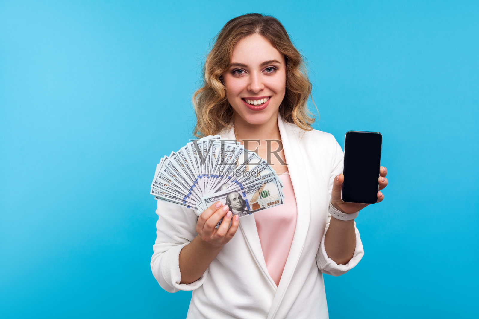 在线支付，货币交易。正面女性的肖像显示美元和手机。蓝色背景照片摄影图片