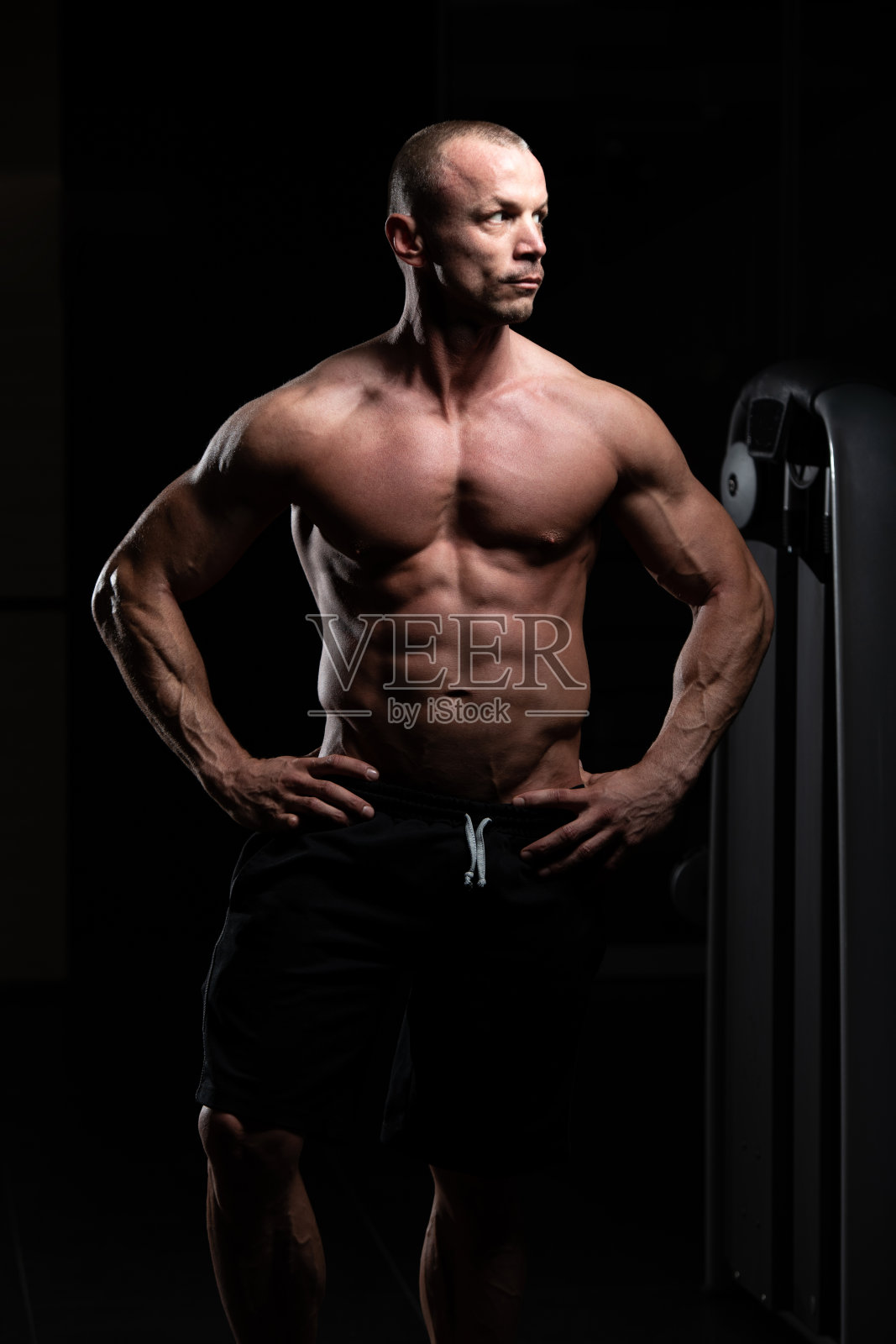 英俊的肌肉男在健身房展示肌肉照片摄影图片