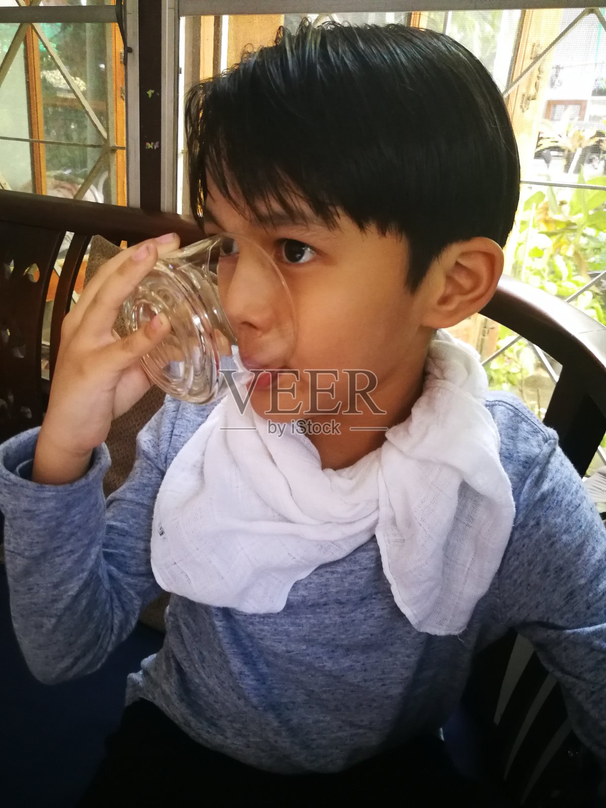 泰国男孩在家放松。照片摄影图片