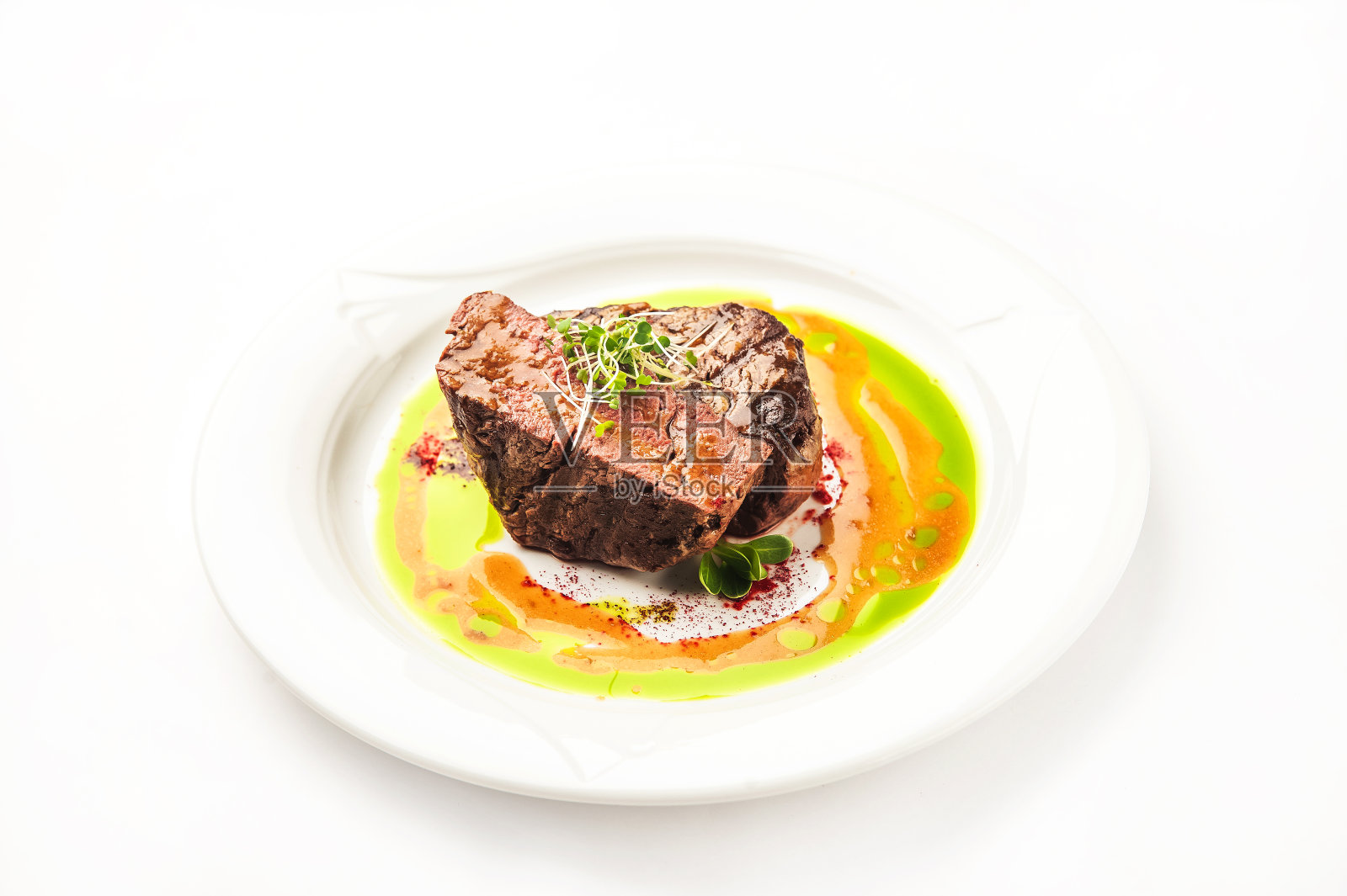 餐馆里的龙卷风特写。牛里脊牛排与微绿色在一个白色的盘子和拷贝空间。照片摄影图片