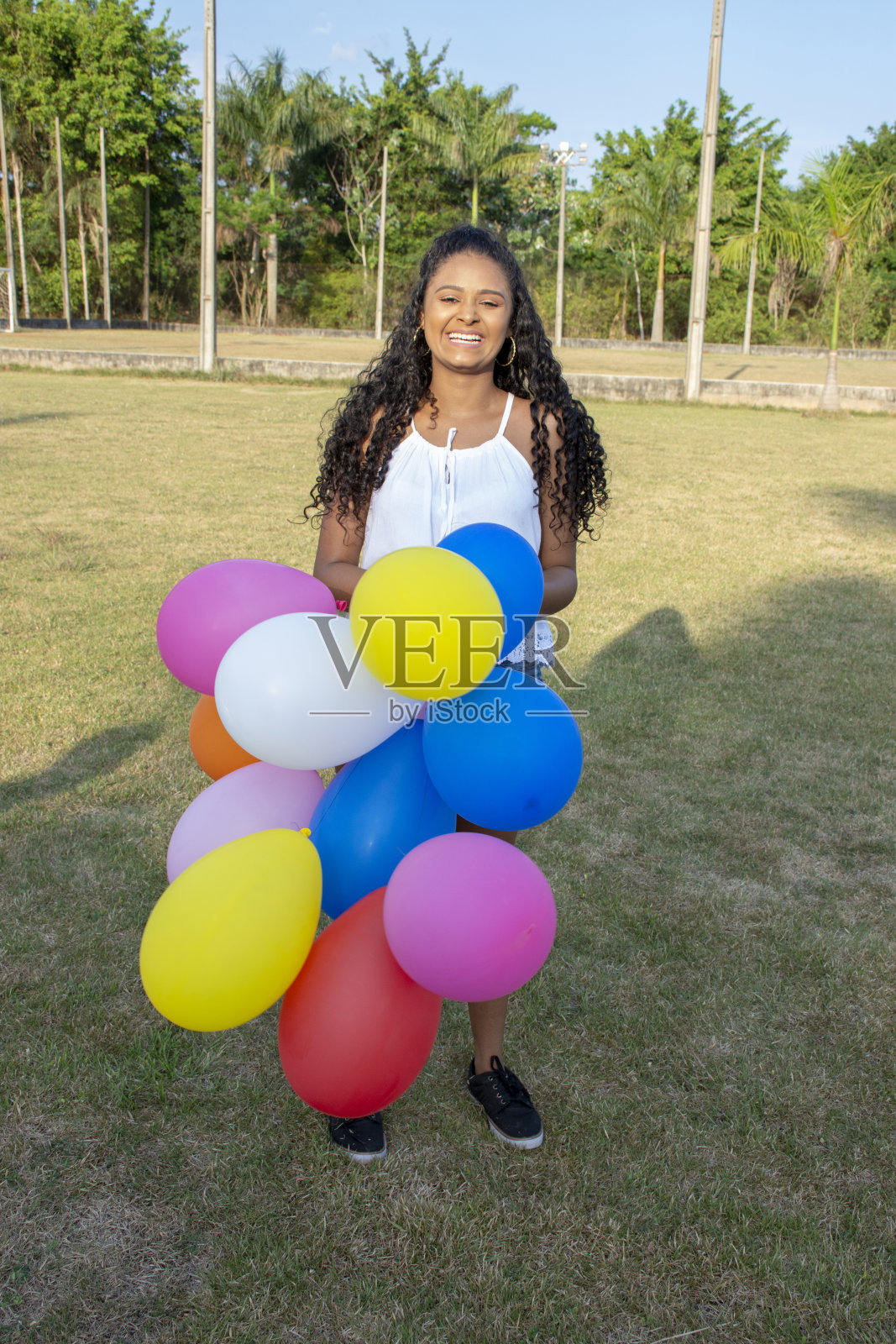 漂亮的年轻女子拿着彩色气球在放松的时刻照片摄影图片