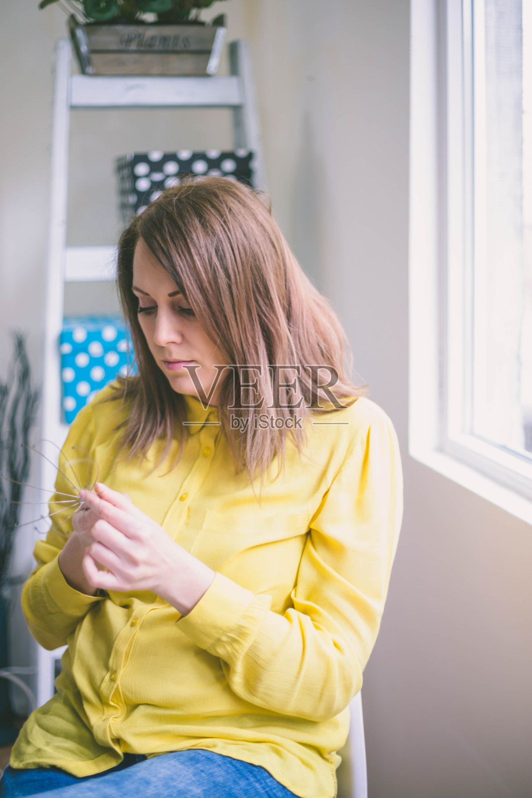漂亮女孩坐在明亮的办公室里，照片摄影图片