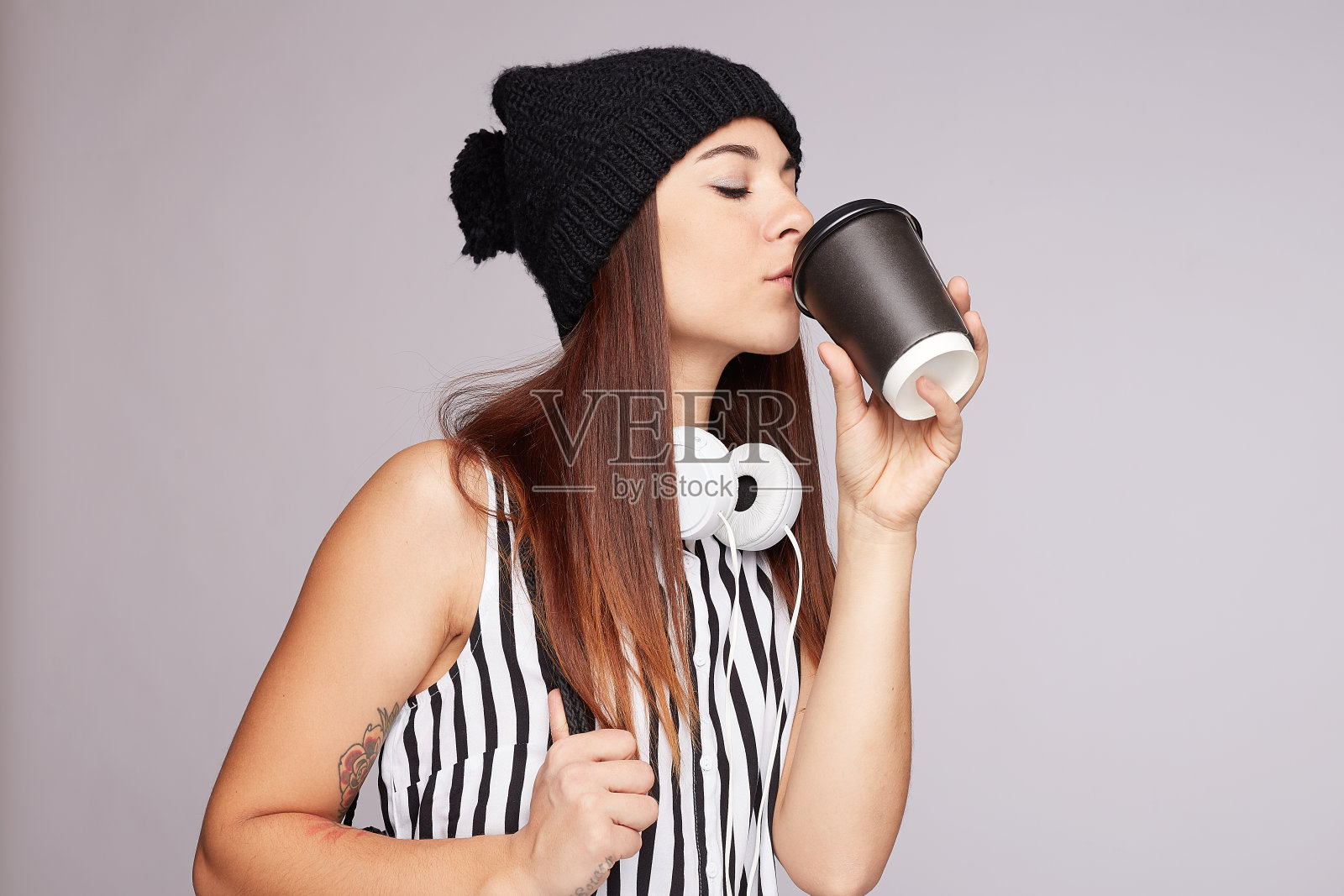 年轻漂亮的女人在室内喝外卖咖啡照片摄影图片