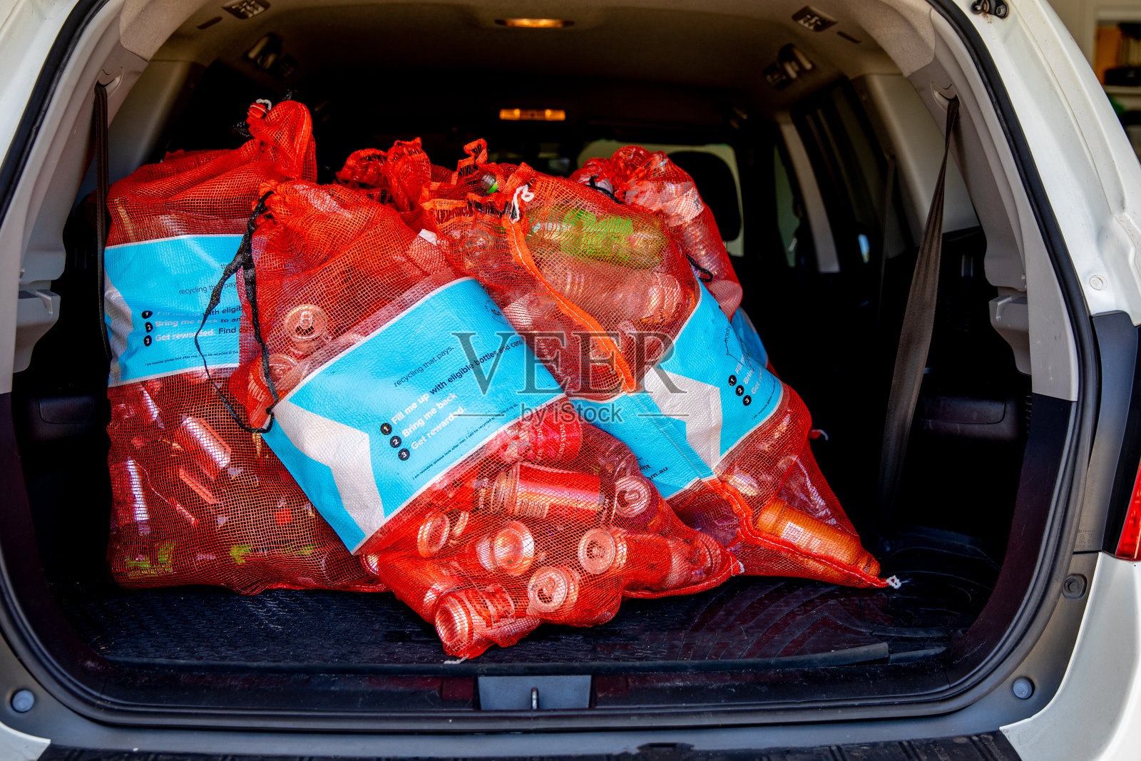 一个澳大利亚小男孩在数回收的瓶子和罐子照片摄影图片