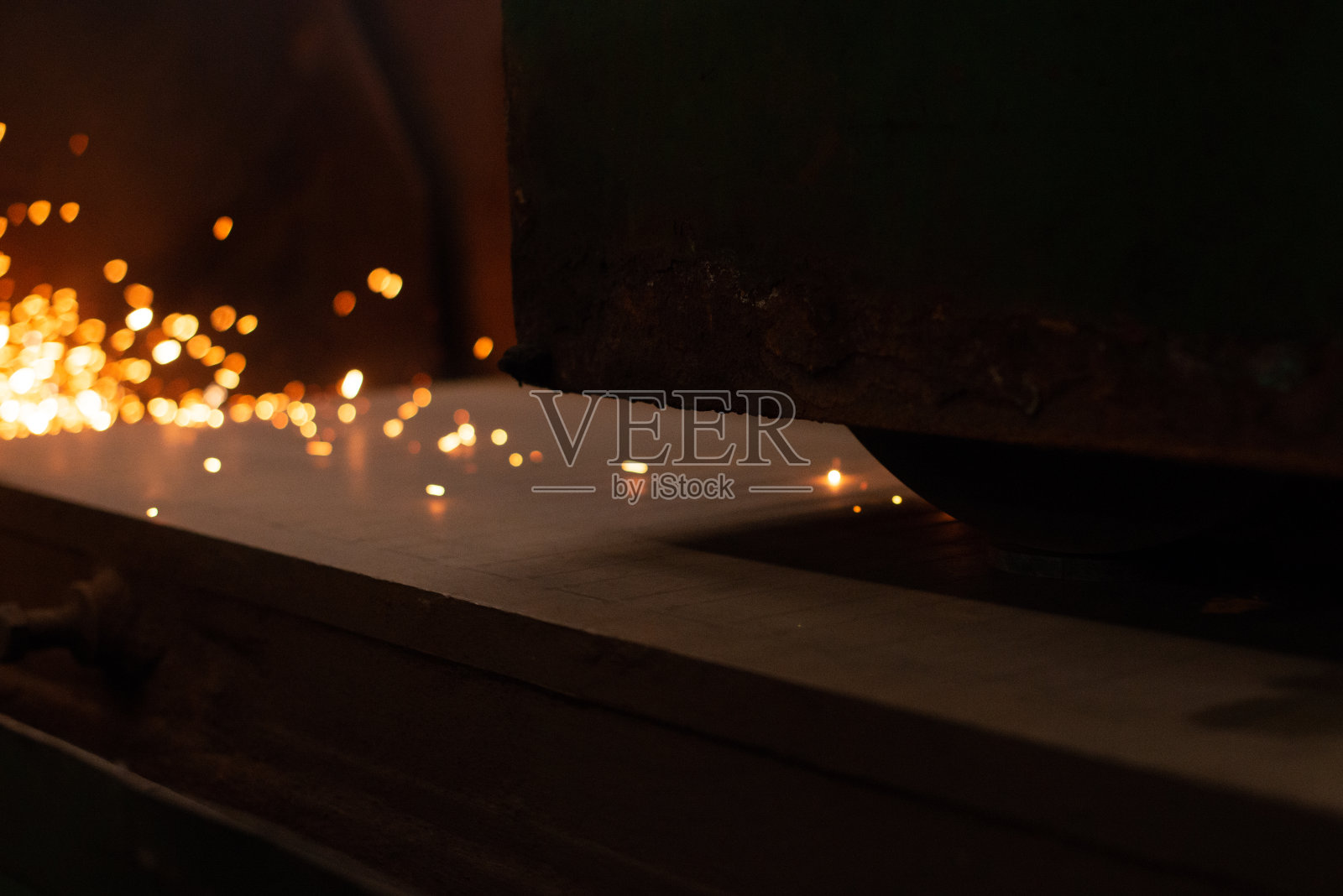 带有火花的金属板材。数控金属激光切割，现代工业技术。制造完成的部分。照片摄影图片