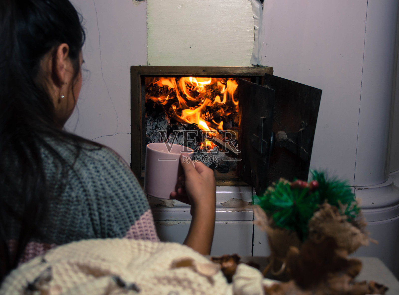 女孩坐在壁炉旁照片摄影图片