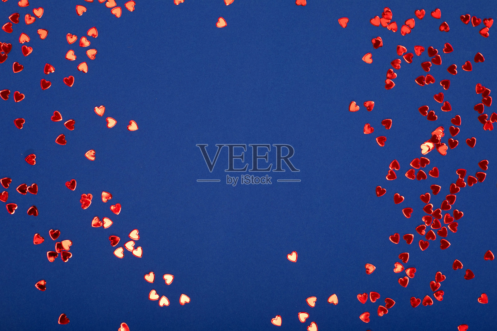 红色闪亮的心在蓝色的背景。照片摄影图片