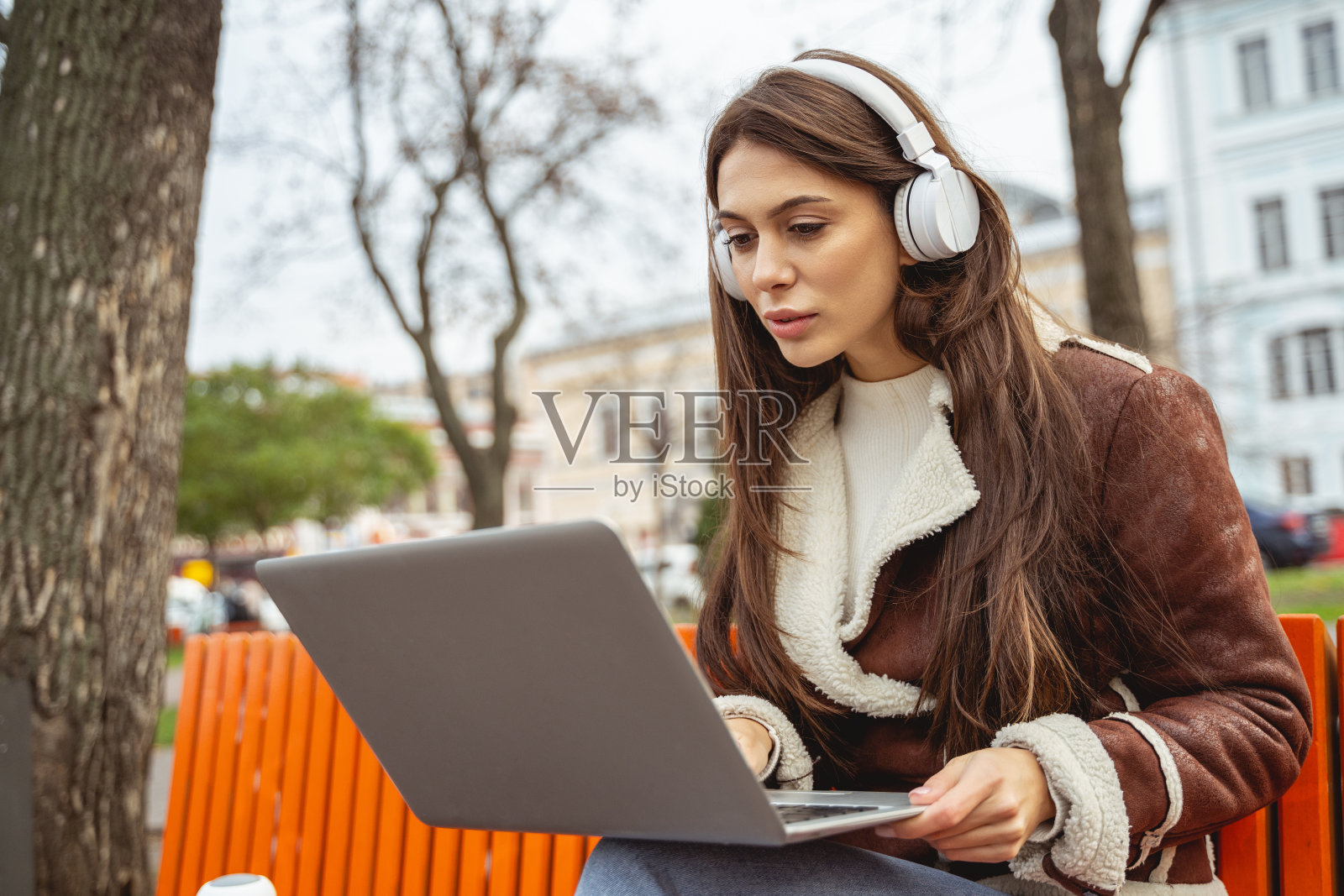 专注的年轻女性盯着笔记本电脑的屏幕照片摄影图片