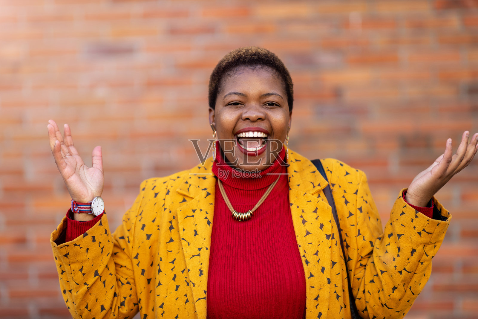 在一堵墙前举起双臂的快乐女人照片摄影图片