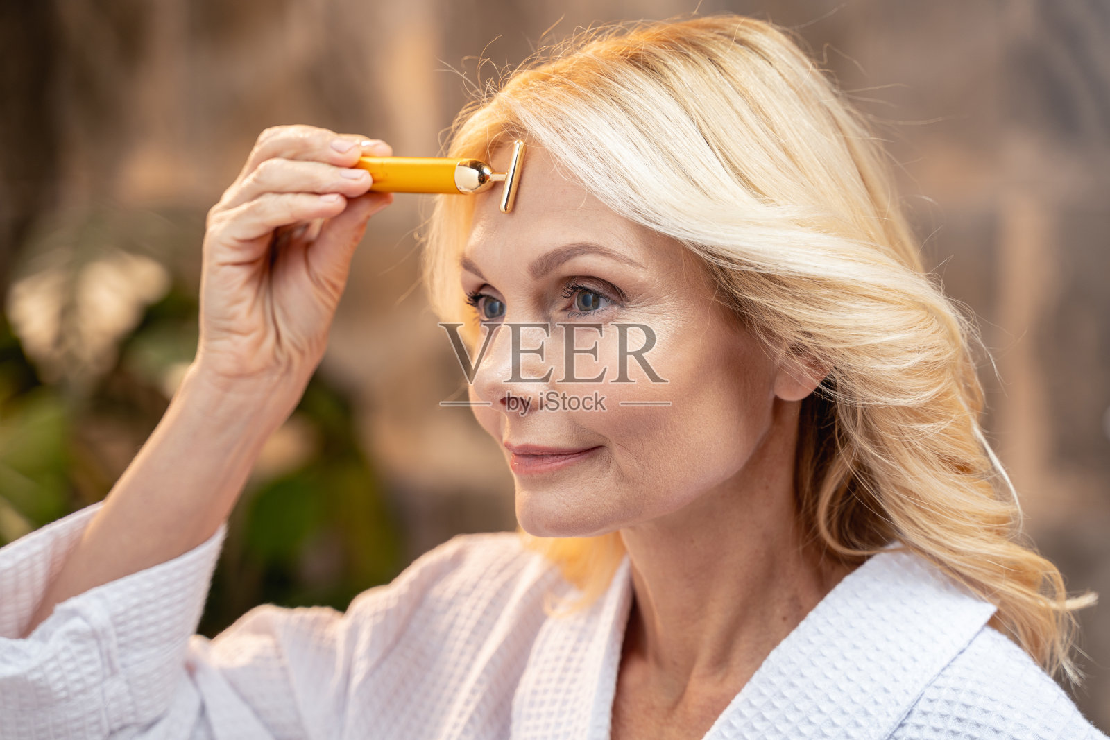 有面部按摩器的漂亮白人女士照片摄影图片