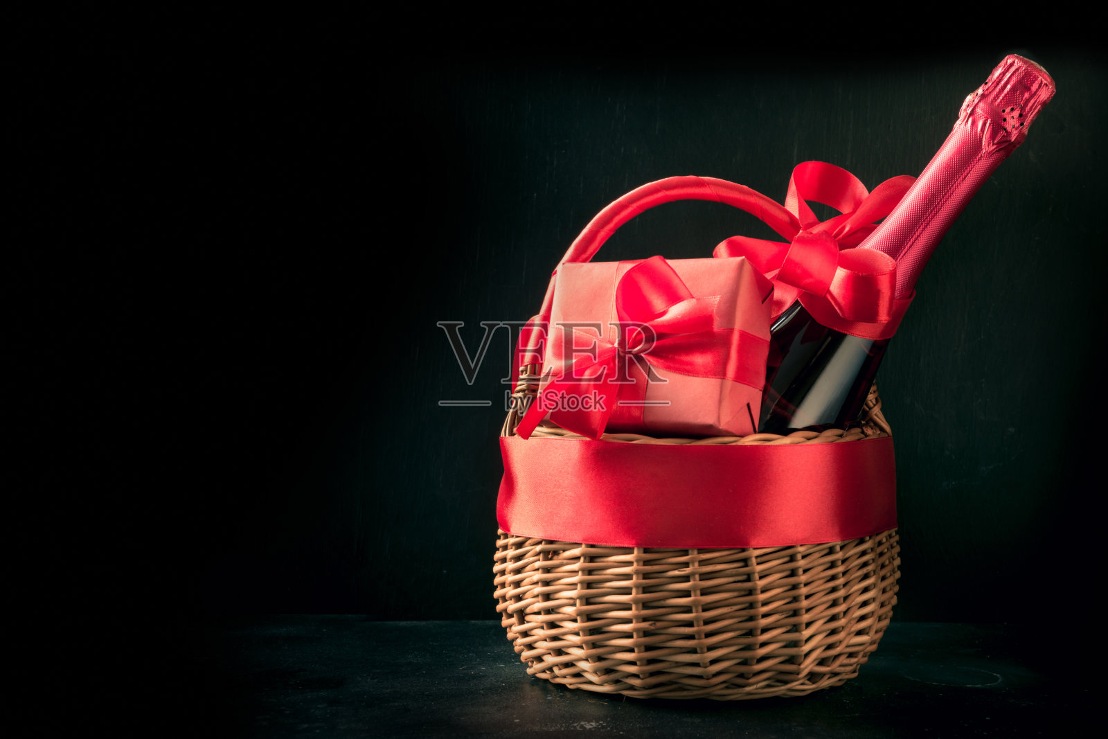 礼物篮，红色礼物，黑色香槟瓶。孤立。浪漫的礼物。照片摄影图片