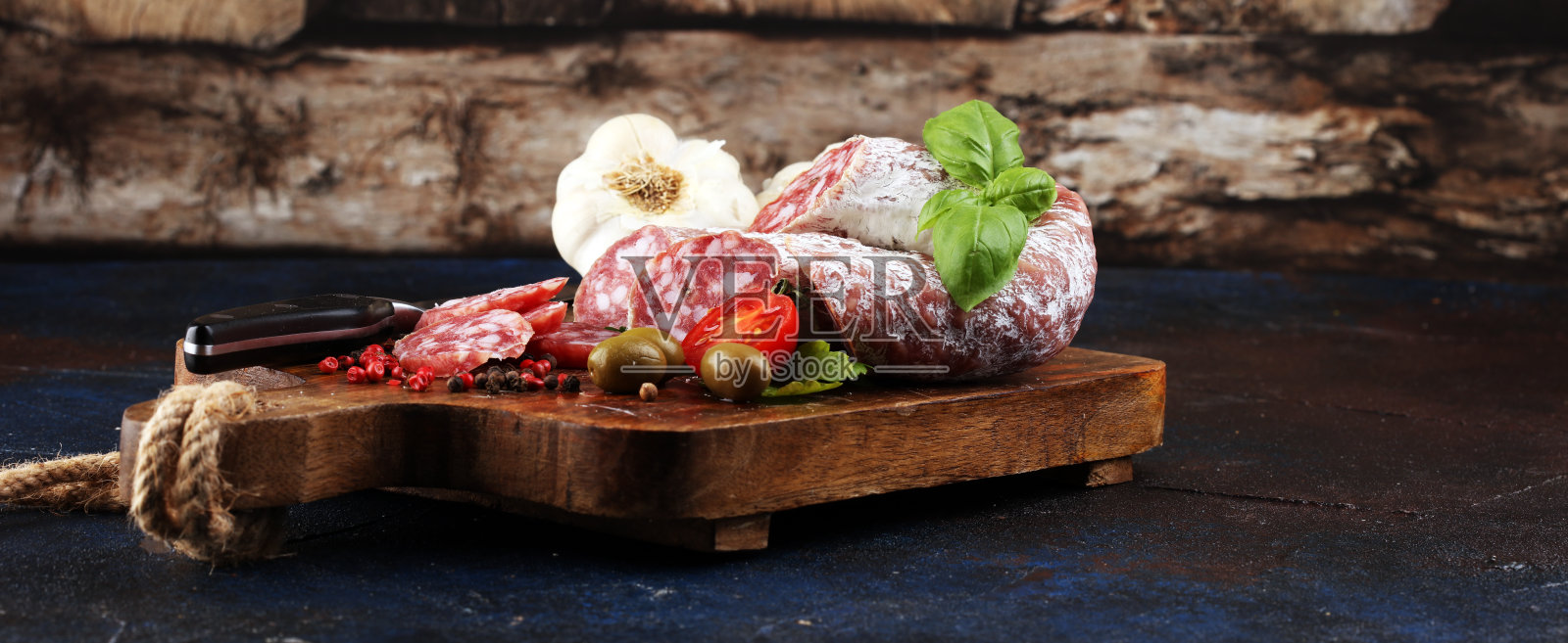 木纹背景上切成薄片的意大利腊肠。照片摄影图片