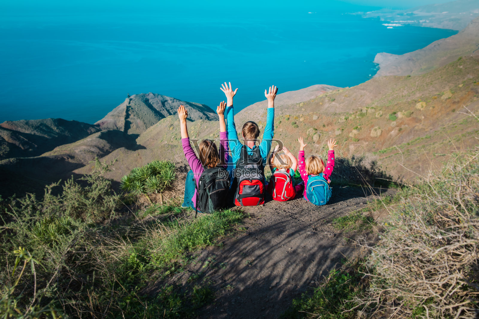 幸福的妈妈和爸爸带着孩子在海边山间旅行，加那利群岛家庭旅行，西班牙照片摄影图片