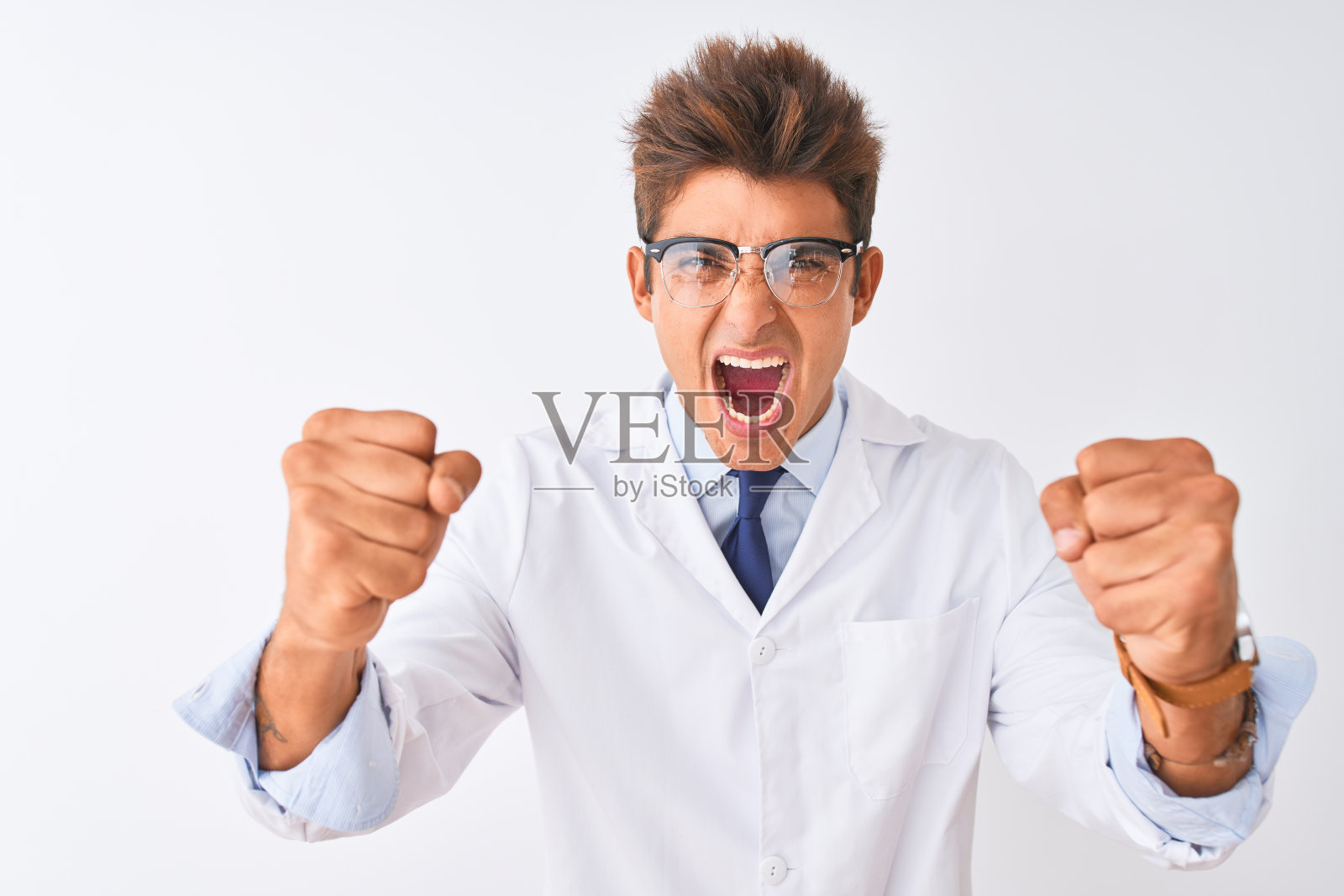 年轻英俊的科学家男人戴着眼镜和外套在孤立的白色背景愤怒和疯狂举起拳头沮丧和愤怒的同时，喊着愤怒。愤怒和侵略性的概念。照片摄影图片