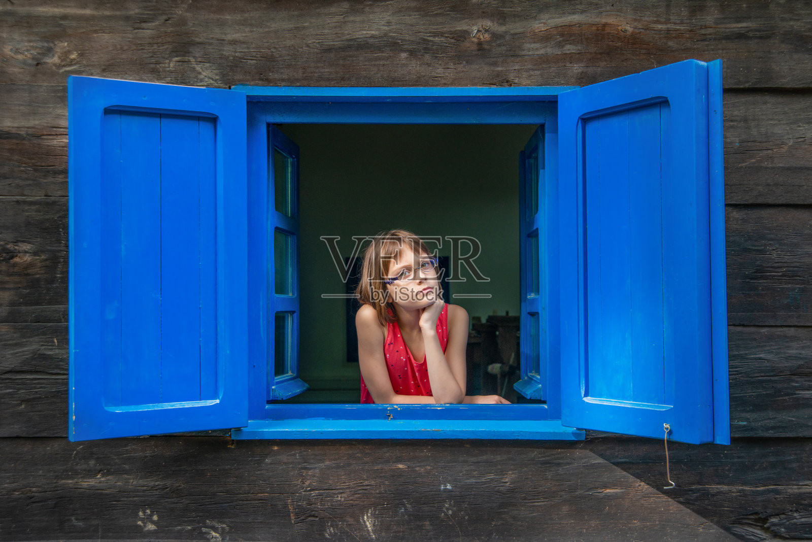 女孩望着窗外照片摄影图片