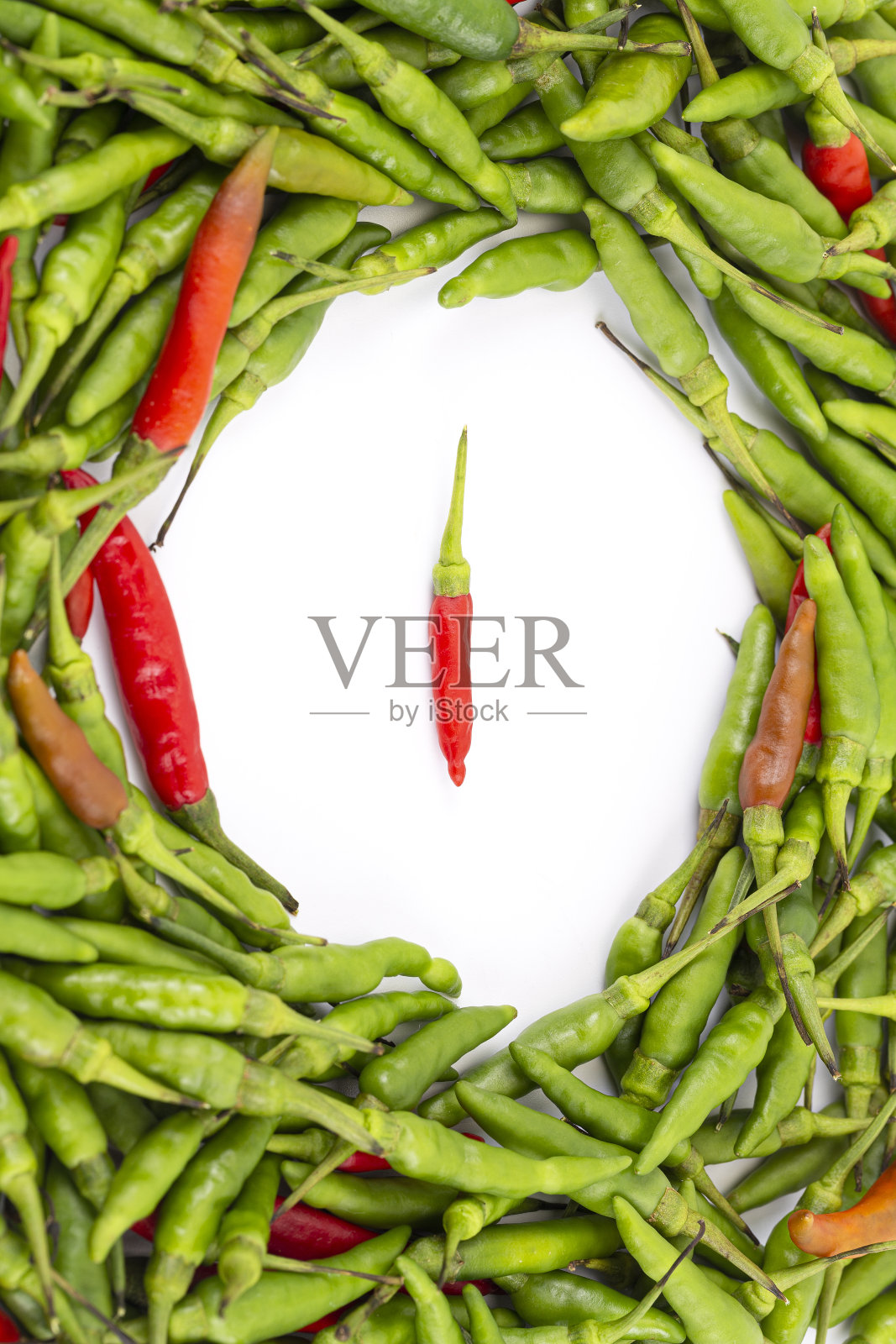 一种小的红辣鸟辣椒，周围是新鲜的红绿混合辣椒，呈圆形照片摄影图片